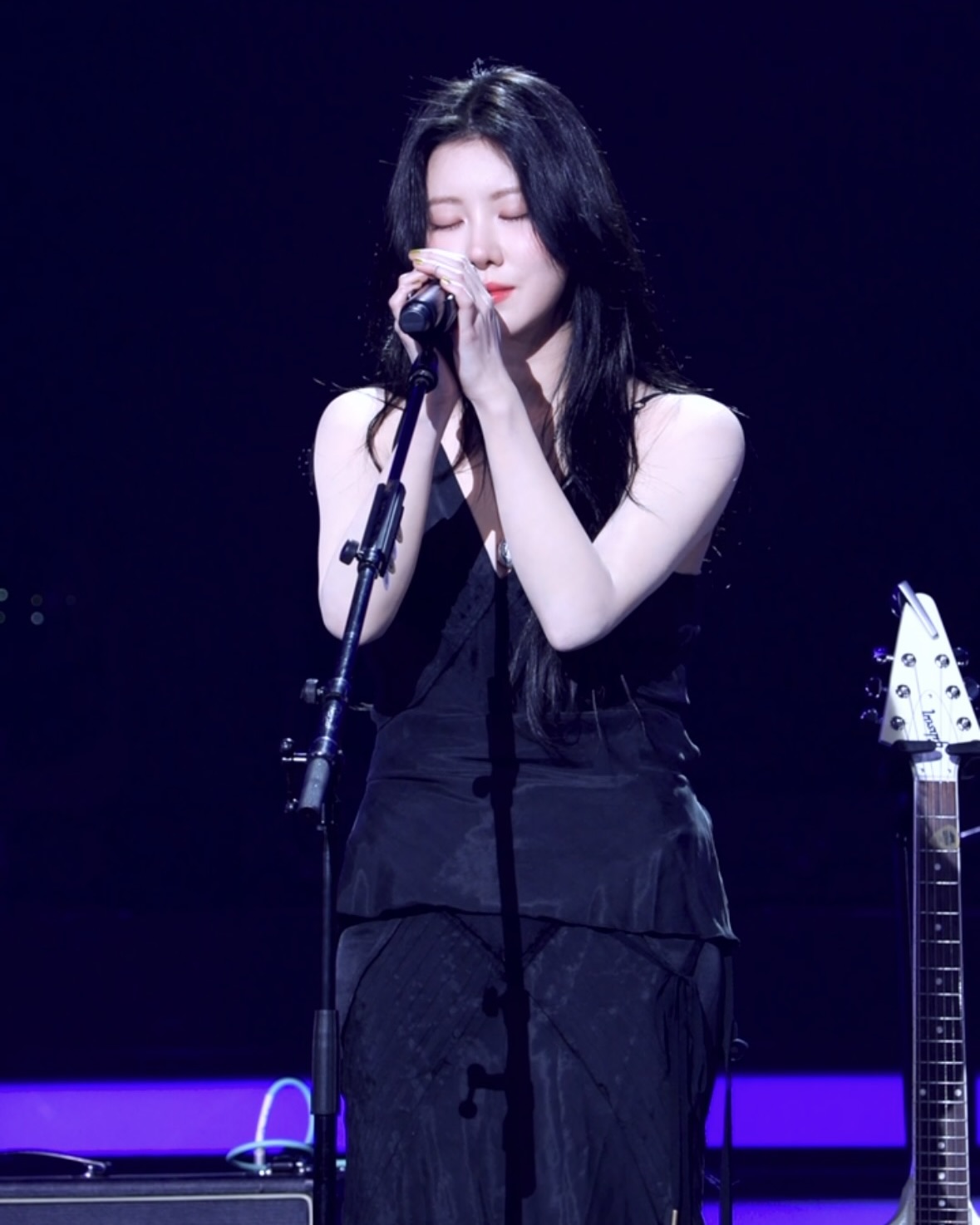 역시 예쁜거 입었네 백예린🧐

8년 만에 공중파에 출연한 백예린. 오랜만의 방송 출연에도 여전히 감각적인 스타일링으로 시선을 사로잡았는데요. 평소 타투와 빈티지한 감성이 어우러진 스타일을 즐기던 그녀는 이번에는 타투를 모두 가리고 한층 깔끔한 룩을 선보였습니다. 하지만 여전히 백예린다운 무드가 살아 있었죠.

백예린 하면 빼놓을 수 없는 아이템이 바로 원피스입니다. 이번에도 그녀는 미러 팔레이스(Mirror Palais)의 마릴린 플로럴 드레스(Marilyn Floral Dress)를 선택했는데요. 잔잔한 플로럴 패턴과 부드러운 실루엣이 돋보이는 원피스로, 로맨틱하면서도 클래식한 분위기를 연출했습니다. 특히 백리스 디자인이 더해져 뒷모습까지 완벽한 스타일링을 완성했죠. 자연스럽게 흐르는 웨이비한 헤어스타일과 함께 그녀만의 감성이 더욱 돋보였습니다.

더 발룬티어스 무대에서는 완전히 다른 분위기를 보여줬습니다. 플로럴 원피스와 상반되는 올블랙 룩을 선택했는데요. 케이엔더블유엘에스(KNWLS) 브랜드의 엘리시르 슬립 탱크 톱(Elisir Slip Tank Top)과 엘리시르 미디 스커트(Elisir Midi Skirt)를 셋업으로 착용하며, 시크하면서도 세련된 무드를 강조했습니다. 실키한 소재의 탱크 톱과 미디 스커트 조합이 그녀의 우아한 실루엣을 더욱 돋보이게 했죠. 탱크톱은 285달러로 한화 약 40만 원대, 스커트는 775달러로 약 110만 원대입니다.

무대의상까지 직접 셀렉하는 백예린답게, 그녀만의 독보적인 스타일이 이번에도 빛을 발했습니다. 감성적인 플로럴 원피스부터 강렬한 무대 의상까지, 완벽하게 다른 두 가지 스타일을 소화하며 역시 ‘사복 여신’다운 면모를 보여줬죠. 앞으로도 그녀만의 감각적인 패션을 더 자주 만나볼 수 있길 기대해봅니다🙏
 이미지7