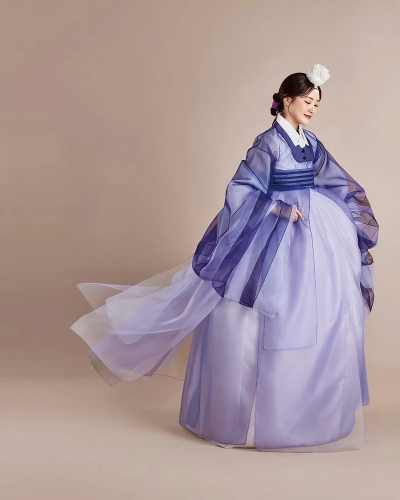요즘 한복은 어떤 걸 입어?🔍
삼일절을 맞아 요즘 한복 트렌드에 대해 이야기해볼까요? 한복 하면 단아한 멋이 먼저 떠오르지만, 요즘은 새로운 스타일링이 속속 등장하면서 또 다른 매력을 보여주고 있는데요. 특히 눈에 띄는 트렌드는 바로 갈래치마입니다.
예전 한복의 치마는 한 겹으로 되어 있어 A라인으로 깔끔하게 퍼지는 실루엣이 일반적이었는데요. 최근 유행하는 갈래치마는 여러 겹의 천이 겹쳐져 있어 더욱 풍성한 볼륨감을 연출합니다. 걸을 때마다 다른 색감과 소재가 살짝 보이면서 한층 더 화려한 무드를 자아내죠.
실제로 뉴진스의 민지는 깊이감 있는 블루 톤의 갈래치마를 입고 단아한 분위기를 선보였고, 다니엘은 무릎길이 정도 오는 짧은 기장의 한복을 선택해 보다 경쾌한 스타일을 완성했는데요. 이렇게 길이에 따라 분위기가 달라지는 것도 갈래치마의 매력 중 하나입니다.
특히 사진을 찍을 때 더욱 예쁘게 연출되는 스타일이라 궁궐 나들이, 웨딩 촬영, 특별한 행사에서도 인기가 높아지고 있습니다. 뉴트로 트렌드와 맞물려 현대적인 감각을 더한 디자인도 많이 등장하면서, 전통적인 한복과는 또 다른 매력을 선보이고 있죠.
다가오는 봄, 한복을 입을 일이 있다면 트렌디한 갈래치마 스타일에 도전해보는 건 어떨까요? 전통미는 살리면서도 색다른 무드를 연출할 수 있는 최고의 선택이 될 거예요🌸
이미지7