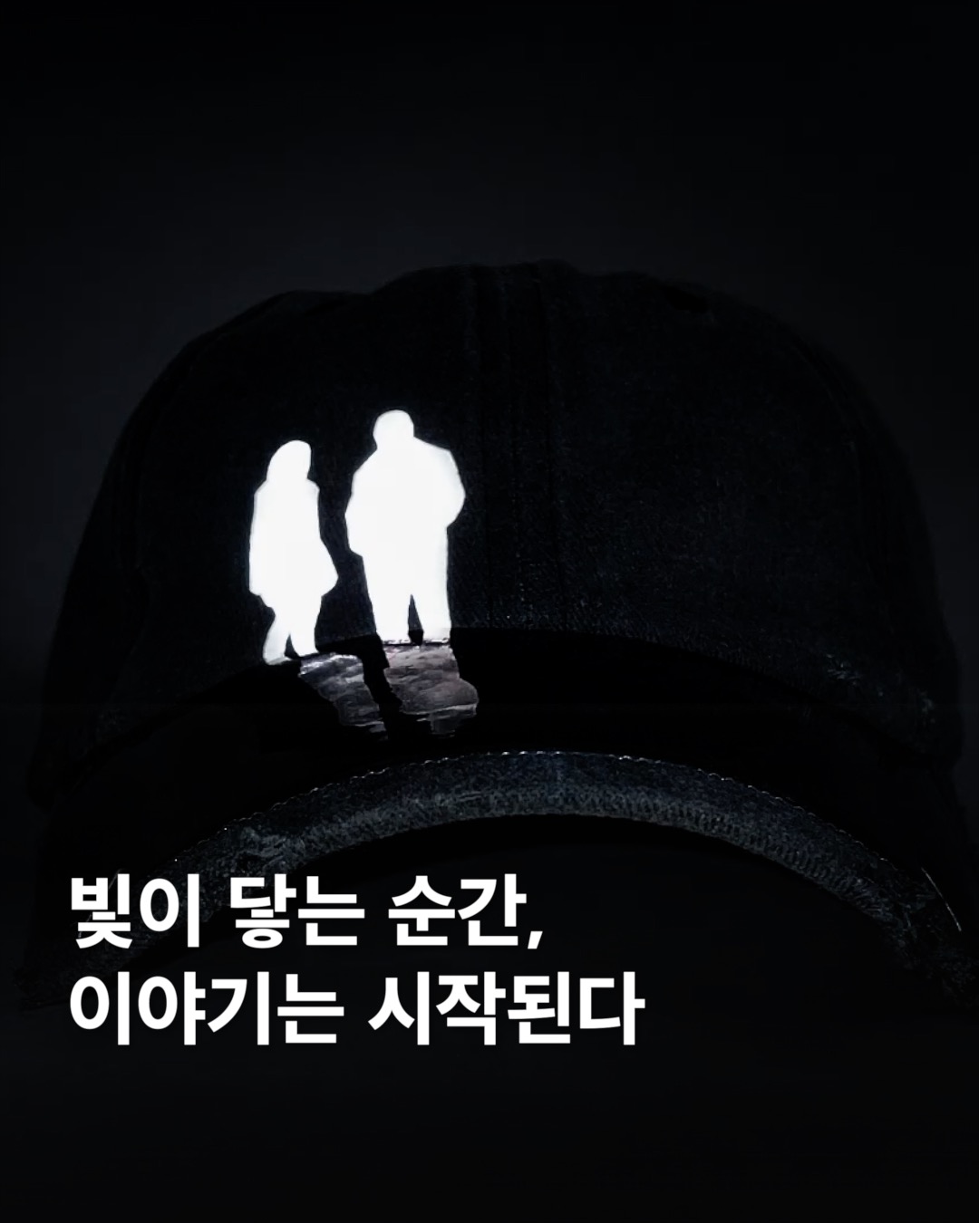 빛이 닿는 순간, 이야기는 시작된다

밤의 도시를 걷다 보면, 뜻밖의 순간에 빛이 만들어내는 장면을 목격하게 됩니다. 자동차 헤드라이트, 가로등, 혹은 스마트폰의 불빛처럼 일상적인 광원들이 만들어내는 반사는 그 순간을 특별하게 만들죠. 아스트랄의 리플렉티브 햇은 바로 그런 찰나의 마법을 입체적인 디자인으로 구현합니다.

겉보기엔 단순한 실루엣이지만, 빛을 만나면 전혀 다른 이야기를 들려주는 이 모자는 두 인물이 마치 물가에 서 있는 듯한 형상을 담고 있는데요. 그 아래에는 그들의 실루엣이 잔잔한 물에 비치듯 섬세하게 반사되죠. 이 리플렉티브 햇은 시선과 관계, 그리고 우리가 바라보는 ‘기억’에 대한 메타포이 아닐까요? 이미지