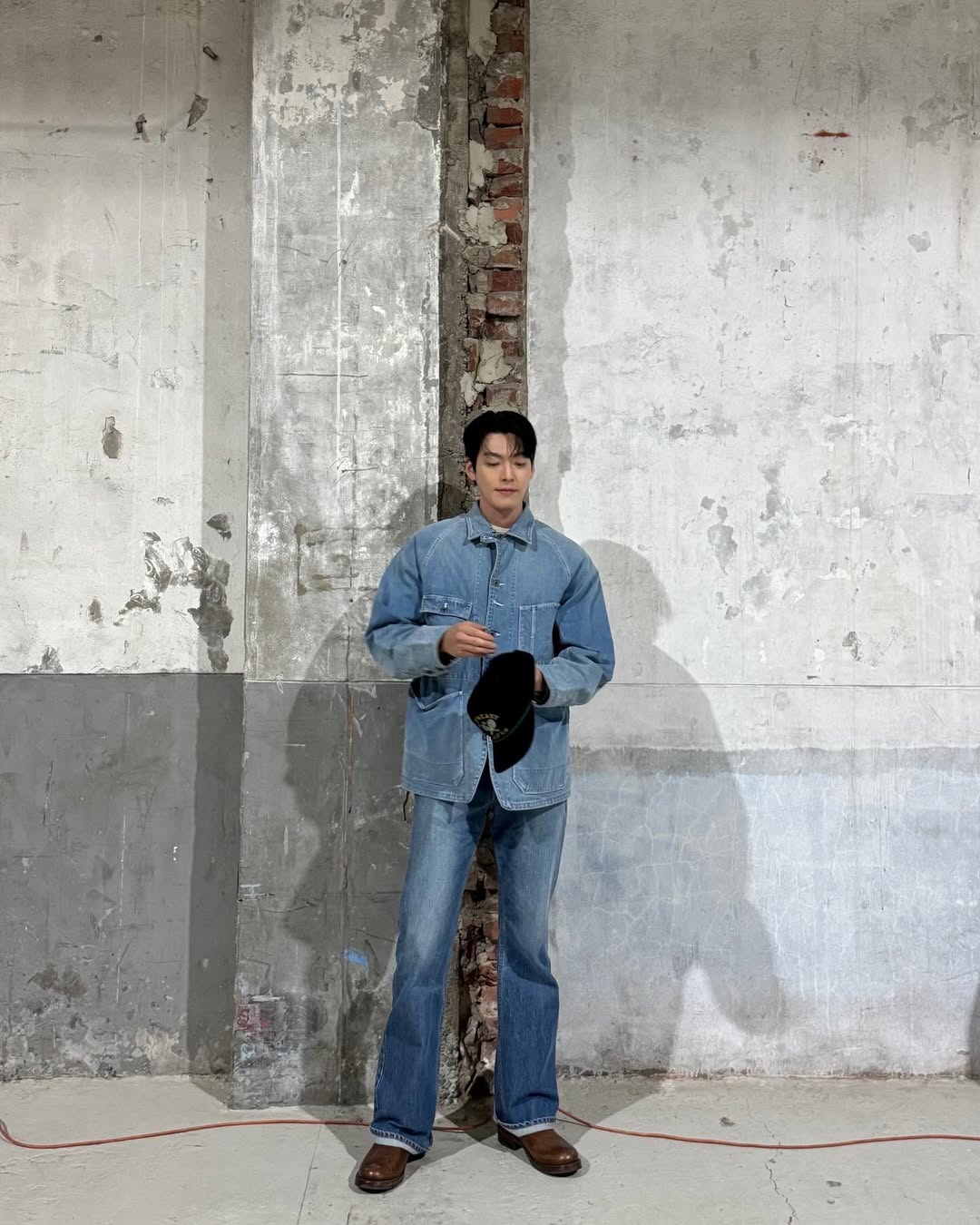 김우빈의 청청코디 👖

김우빈이 선택한 데님 재킷은 오버핏 실루엣에 큼직한 포켓 디테일이 돋보이며, 전형적인 워크웨어 무드를 연상시키는데요. 하지만 그것이 주는 인상은 전혀 무겁지 않습니다. 오히려 여유로운 핏과 가볍게 풀어낸 스타일링 덕분에 데님이 지닌 투박함보다는, 자연스럽고 성숙한 멋이 먼저 느껴지죠.

특히 상·하의 모두 데님 소재임에도 불구하고, 워싱의 농도와 톤을 달리해 시각적인 재미를 주고 있는 점이 인상적.

상의는 밝은 중청 계열, 하의는 조금 더 짙은 톤을 선택함으로써 청청 조합의 단점을 세련되게 보완하고 있습니다. 여기에 브라운 계열의 부츠를 매치해 무채색에 가까운 룩에 따뜻한 포인트를 더해주었고, 전체적인 코디에 리듬감을 부여했죠.

또한 볼캡은 캐주얼한 요소로 룩에 여유를 더해주는 역할을 합니다. 블랙 컬러에 옐로우와 그린 자수가 들어간 이 모자는 강한 포인트가 되기보다는 전체 분위기를 무심하게 풀어주는 감각적인 장치로 기능하죠. 마치 꾸미지 않은 듯한 태도 속에 섬세하게 완성된 스타일이 묻어나는 듯합니다. 이미지