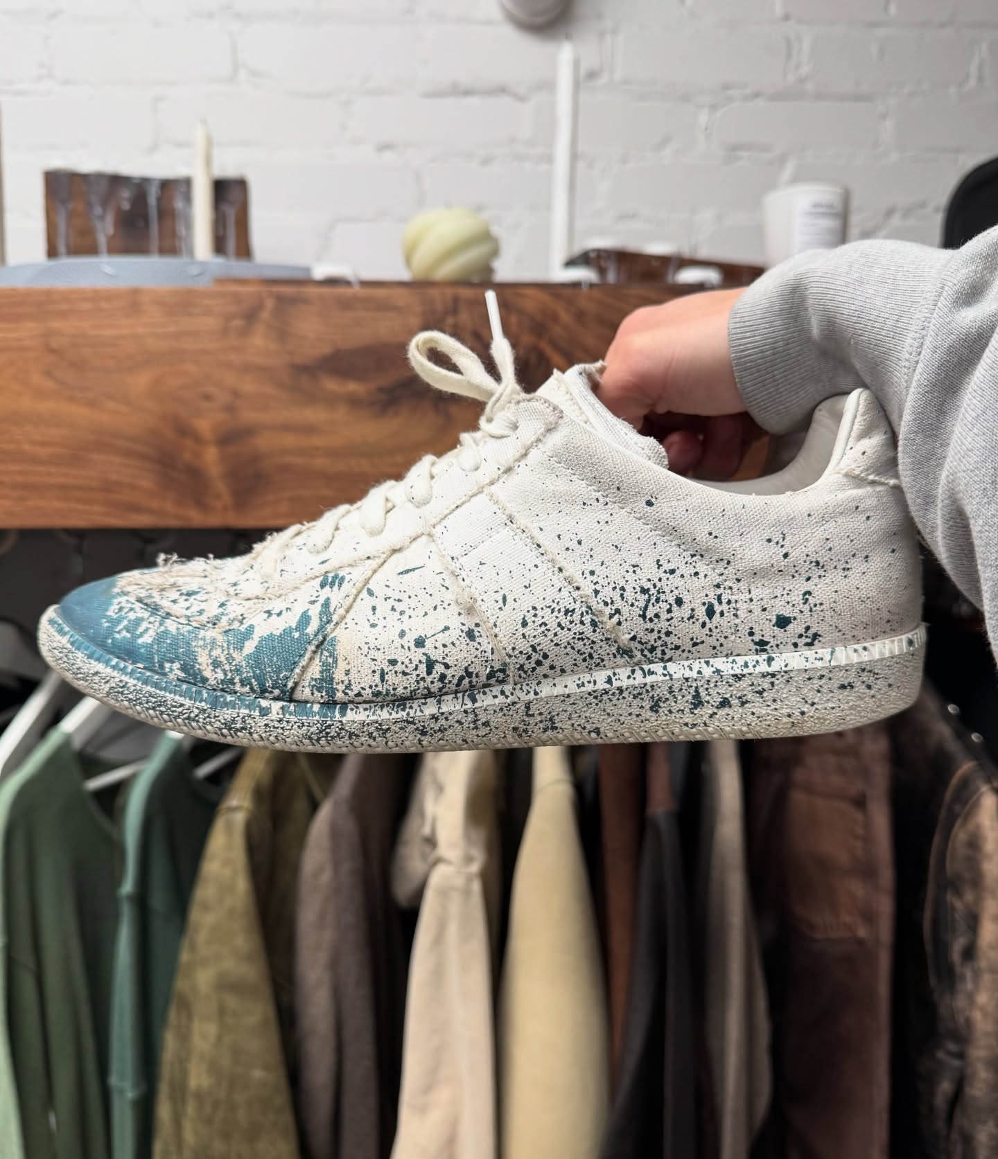 메종 마르지엘라 블루 페인트 스플래터 로우탑 스니커즈로 살펴보는 헤리티지 👟

마르지엘라에 있어 1998년부터 2009년까지의 시기는 패션계에 매우 중요한 시기였습니다.

마르지엘라는 1999년부터 당시에는 생소하던 ‘독일군 트레이너(German Army Trainer, GAT)’를 무대에 끌어올렸는데요.

GAT는 실제로 1970~80년대 서독 군에서 사용된 훈련화로, 벨기에 밀리터리 샵에서 마르지엘라가 구한 것이 시초였습니다.

사진 속 블루 페인트 스플래터 모델은 그의 시그니처인 ‘페인트 드리핑’ 기법을 적용. GAT 실루엣 위에 정제되지 않은 예술처럼 흩뿌려진 디자인이 특징이죠. 잭슨 폴록의 드리핑 기법에서 영감을 얻었다고 합니다. 이미지