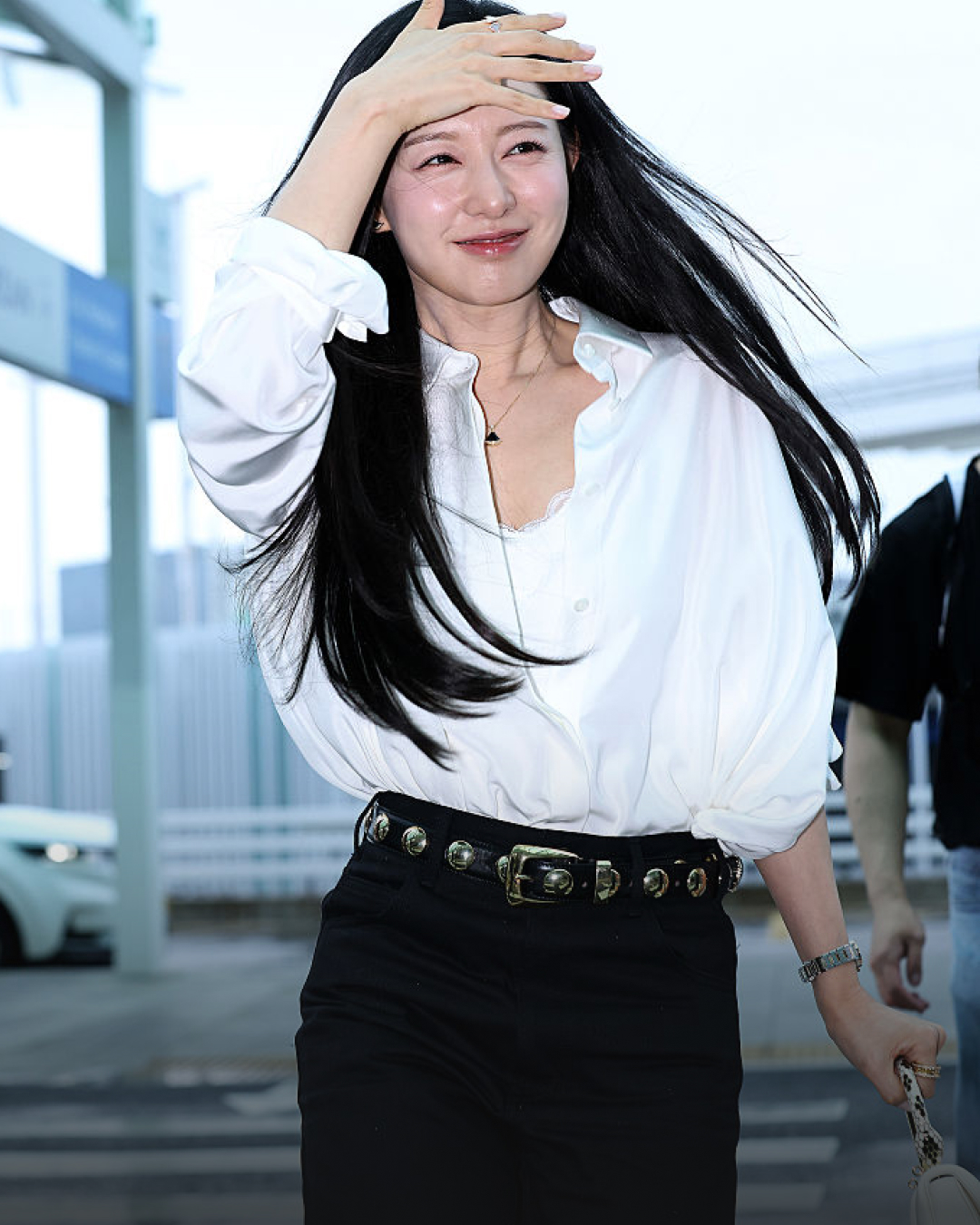 여왕 김지원 출국길, 고급미 폭발✨ 비가 와도 빛나는 김지원의 럭셔리 공항룩🖤  클래식한 블랙 앤 화이트 룩에 포인트 아이템이면 충분합니다.  1. 불가리 불가리 워치, 1,400만 원대 라운드 다이얼과 로즈 골드 컬러가 특징인 시계로, 김지원은 화이트 셔츠 소매를 롤업해 자연스럽게 보이도록 연출하였습니다.  2. 로에베 벌룬 실크 셔츠, 200만 원대 볼륨감 있는 실루엣의 셔츠로, 김지원은 레이스 디테일의 나시와 함께 셔츠 단추를 오픈해 우아한 무드를 완성했습니다.  3. 케이트 스터드 베니 벨트, 100만 원대 실버 스터드 장식이 더해진 벨트는 셔츠와 팬츠의 단정한 조합에 엣지를 더해주며, 전체적인 룩에 포인트를 주었습니다.  4. 르하스 하이라이즈 턴업 와이드 팬츠, 30만 원대 턴업 디테일이 돋보이는 하이라이즈 블랙 팬츠로 김지원은 셔츠를 팬츠 안에 넣어 다리가 길어 보이도록 마무리했습니다. 이미지