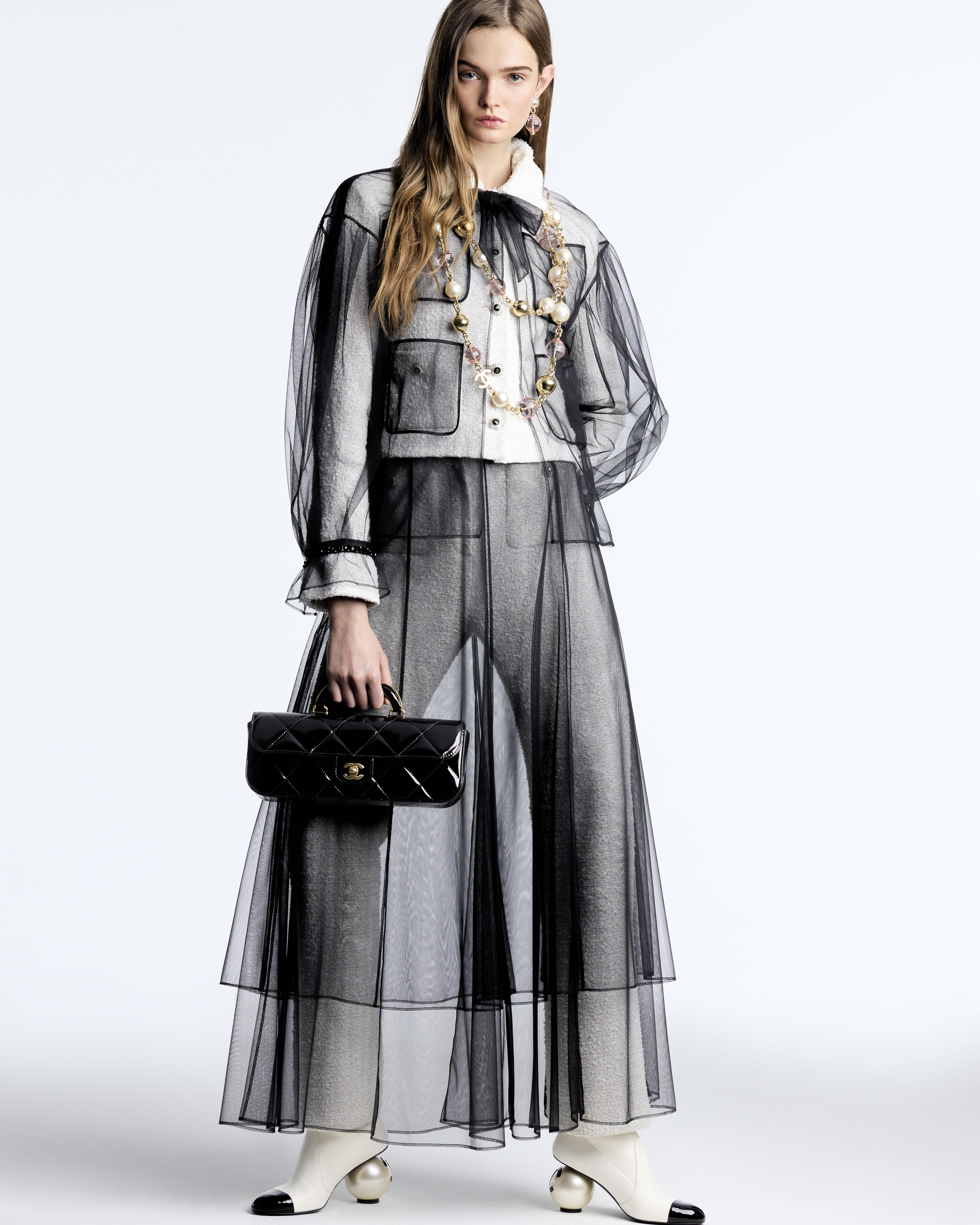 진주 포인트가 이렇게 매력적이라고? 💖
이번 시즌 필수템은 왕진주✨👀 샤넬 25FW에서 확인해 보자

샤넬이 2025/26 FW 레디 투 웨어 컬렉션을 공개하며 주목받고 있습니다. 모델 룰루 테니(Lulu Tenney)와 사진가 안토니 세클라우이(Anthony Seklaoui)가 함께한 이번 컬렉션은 브랜드 특유의 세련된 무드를 감각적으로 담아냈죠.

리본, 진주, 트위드, 투톤 등 아이코닉 요소를 크기와 비율 변화를 통해 신선하게 풀어냈고, 실루엣은 다양한 레이어링이 돋보였죠. 망사 원단의 튤 블라우스와 스커트는 아이보리 수트 위에, 벨벳 셋업은 데님처럼 보이도록 연출해 시각적 재미를 더했습니다.

맥시멀한 주얼리는 클래식한 매력을 더하고, 룩에 화려한 포인트를 주었습니다. 이번 컬렉션은 샤넬의 우아함과 현대적인 감각이 조화를 이루며 새로운 무드를 불어넣었습니다. 이미지5