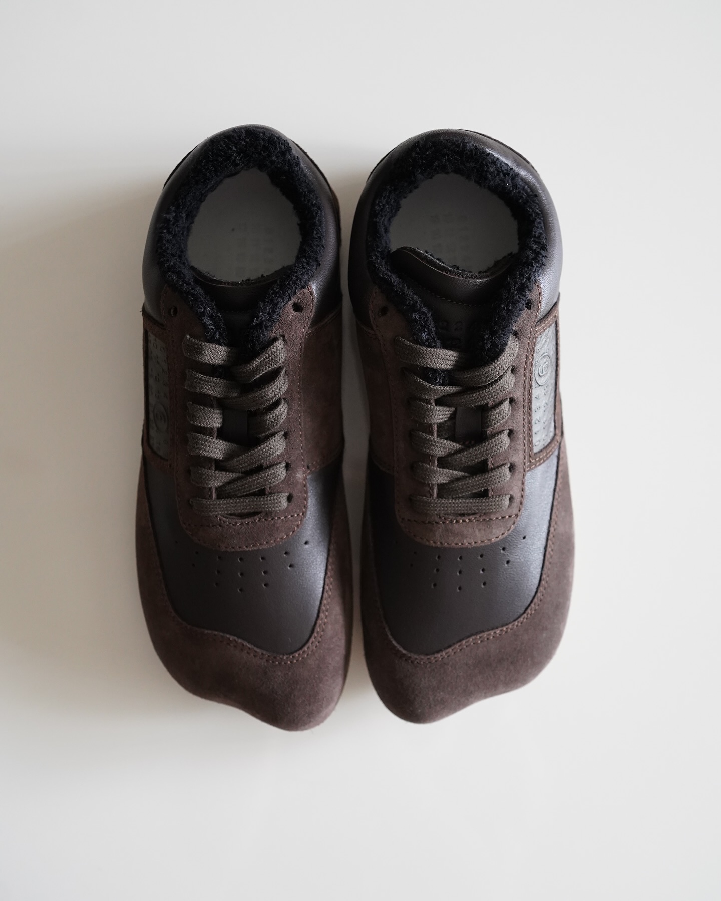 남들 다 신는 운동화 말고 mm6🐻
트렌디한데 과하지는 않은 실루엣과 디테일🖤✨애너타믹 딱이야

mm6의 아이코닉 라인인 애너타믹 스니커즈는 일반적인 스니커즈와 차별되는 유기적 실루엣이 특징입니다. 발등을 따라 자연스럽게 흐르는 라인이 부드럽고 매끈한 형태를 완성해 브랜드 특유의 유니크함과 미니멀 감성을 느낄 수 있죠.

스웨이드와 레더 소재를 활용해 고급스러운 질감이 돋보이고, 패치 로고와 펀칭 디테일은 브랜드 정체성을 나타내죠. 특히 깔끔한 실루엣으로 어떤 룩에도 과하지 않게 세련된 마무리를 더해주는 스니커즈입니다. 이미지