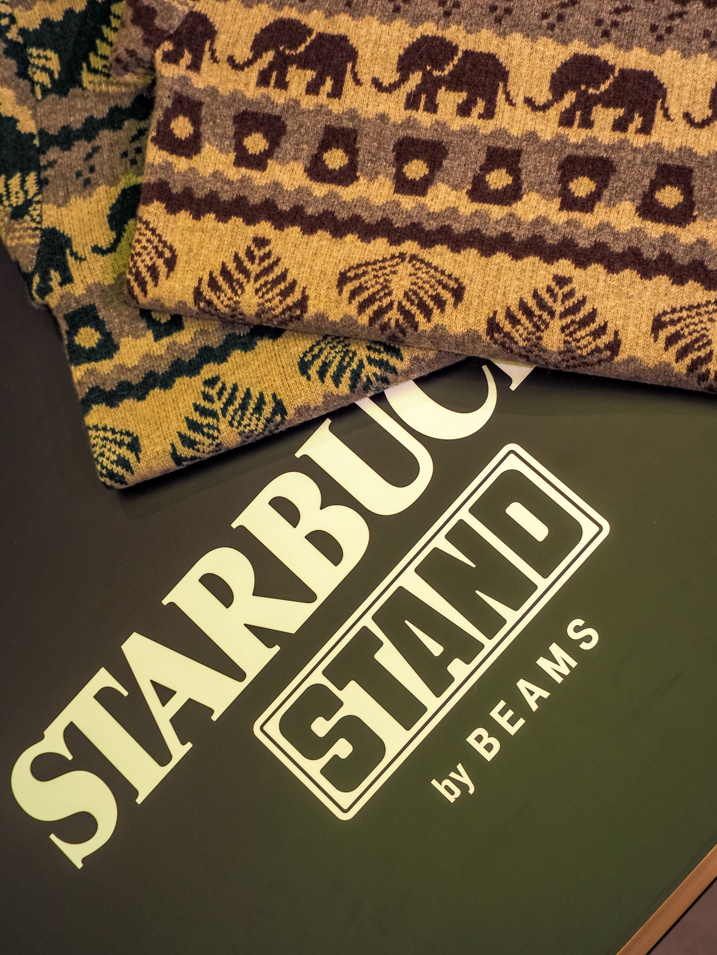 스타벅스 x 빔즈의 이번 테마는?🔍
케냐에서 출발한 빈티지 무드와 이색 아이템 같이 살펴보자💚🤎
스타벅스와 빔즈의 협업은 커피 브랜드와 패션 라이프스타일 브랜드의 만남이라는 점에서 꾸준히 주목받아 왔죠. 이번 협업 역시 새로운 테마 " SEASONAL Collection"으로, 커피 원두 생산 지역 케냐에서 영감을 받은 총 13가지 품목으로 구성되었습니다.
브라운과 옐로, 그린 톤의 케냐 전통 패턴에 코끼리와 리프 모티프가 더해진 플리스는 빈티지한 무드가 느껴지죠. 이 외에도 자카드 크루 니트, 바라클라바, 블루종 등 이색적이고 유니크한 아이템이 더해진 감각적인 협업 컬렉션을 선보였습니다. 이미지6