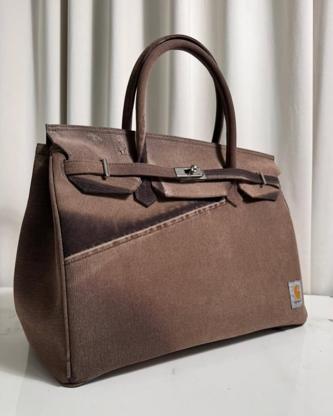 워크웨어 무드🙊🧡칼하트 버킨백
빈티지 칼하트를 해체해 만든 재해석, Another Chance🧰
칼하트 워크웨어가 브랜드 ‘어나더 찬스(Another Chance)’를 통해 정교한 손길로 재해석되었습니다. 닳은 흔적과 바랜 색감, 원단 고유의 결을 살려 만든 이 가방은 오히려 그 불완전함 덕분에 단 하나의 존재가 됩니다. 이탈리아 북부 15km 반경 내에서 완성되는 이 리워크 백은 원단이 지닌 시간의 결을 현대적 미감으로 끌어올립니다.
유니크한 이 가방은, 오래 들수록 멋이 더해지는 감도 높은 실용 아이템으로 화제입니다. 한 번 빈티지 장인의 손 끝을 확인해보세요. 이미지8