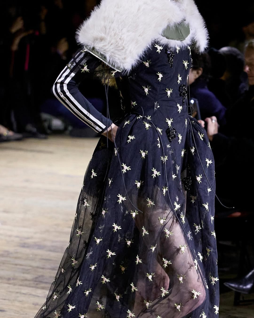 런던패션위크를 흔든 삼선🖤🤍
시몬 로샤와 아디다스 26FW🇬🇧레이스와 트랙자켓 조합 주목!!
이번 런던패션위크에서 가장 주목받은 장면 중 하나는 시몬 로샤와 아디다스의 협업 런웨이였습니다. 레이스와 튤 실루엣 위에 더해진 아디다스의 세 줄과 트랙 자켓을 ‘스포츠 코드의 재해석’으로 분석하며, 브랜드 아카이브를 하이패션 구조 안으로 편입한 사례였습니다.
특히 스니커즈와 트랙 팬츠를 드레스 룩과 병치한 스타일링을 통해 스포츠웨어가 보조 아이템이 아닌 실루엣의 중심 축으로 재배치됐다고 구체적으로 보여줬습니다. 이미지8