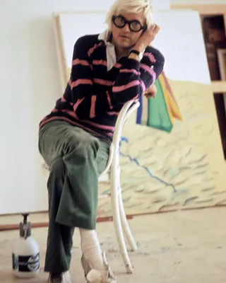 가장 다채로운 색을 입던 거장🎨
우리 곁을 떠난 데이비드 호크니, 그의 스타일을 기억하며 기립니다
그는 캔버스 위에만 그림을 그린 게 아니라 매일의 옷차림마저 작품처럼 연출한 스타일 아이콘이었죠. 트레이드마크인 두꺼운 뿔테 안경, 위트 넘치는 스트라이프 셔츠, 쨍한 컬러풀 카디건의 조합은 늘 전 세계 패션 피플에게 영감을 줬습니다.
2022년엔 버킹엄궁 오찬에 점잖은 수트와 쨍한 옐로우 크록스를 매치해 세상을 놀라게 했죠. 격식보다 편안함을 택한 거장의 마이웨이였어요. 찰스 3세 국왕은 "당신의 노란 크록스, 정말 탁월한 선택이군요"라며 쿨하게 인정했습니다.
비록 떠났지만, 그가 남긴 색채와 쿨한 감성의 룩은 오래 기억될 거예요. 이미지