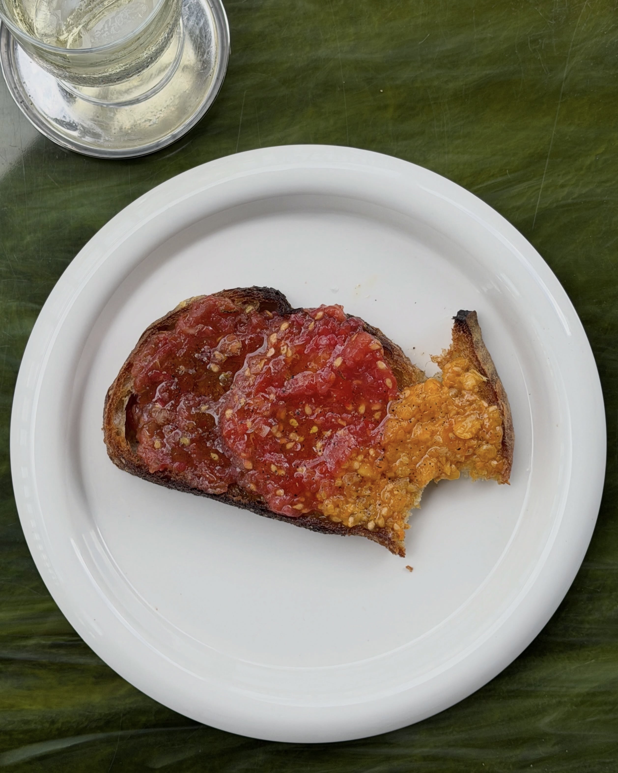 재료 4개로 끝내는 스페인의 맛🇪🇸
요즘 인스타그램 알고리즘에 자주 보이는 이 요리 뭔지 궁금하셨죠? 🙌🏻
우리에겐 생소한 이 음식이 해외에선 간단하게 요리할 수 있어 대중적으로 알려져있는 음식인데요. 패션앤스타일이 지금 뉴욕의 가장 핫한 디자이너 샌디 리앙의 인스타그램 스토리에서도 포착했습니다.👀
레시피는 아주 간단합니다! 스페인어로 '판 콘 토마테'라 불리는 이 '토마토 브레드'를 지금 만들어보세요.
📌준비물
빵(사워도우 또는 치아바타), 토마토(큰 생토마토를 사용해요), 엑스트라버진 올리브 오일, 통마늘, 소금(바다 소금을 사용하면 풍미가 더 좋습니다)
📌레시피
1. 빵에 기름을 바르고 토스트합니다.
치아바타 빵을 세로로 반으로 자른 후 5cm 두께로 썰어줍니다. 좋은 올리브 오일을 바르고 베이킹 시트에 펼쳐 놓습니다. 오븐의 그릴에서 약 15cm 떨어진 곳에 놓고 3분 이내로 노릇하게 구워줍니다.
2. 토마토를 강판에 갈아주세요.
토마토 윗부분에 작은 칼집을 내고 강판을 이용해 갈아줍니다. 소금과 라임즙(선택 사항)을 약간 넣어 간을 합니다.
3. 토마토 빵을 만드세요.
빵이 다 구워지면 뜨거운 빵 위에 마늘을 문지릅니다. 빵 위에 토마토 퓌레를 바르고 기호에 따라 파슬리나 후추를 올려 먹어요.
뻔한 토스트가 지겨워졌다면, 이번 주말엔 이 소박하고 강렬한 맛에 빠져보세요! 이미지3