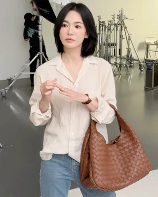 혜교언니 요즘 자주드는 보테가🤎🖤 오래 봐도 계속 좋은 무드👜 송혜교가 최근 든 보테가 베네타 3가지. 레드 캄파나, 브라운 코리에르, 블랙 베이비 베네타. 컬러는 제각각인데 셋 다 브랜드 이름이 겉으로 드러나는 자리가 없습니다. 대신 가죽을 가늘게 잘라 엮은 인트레치아토가 표면을 채웁니다. 보테가 베네타가 1966년부터 써온 방식이고, 로고를 붙이지 않아도 브랜드가 읽히는 이유죠. 캄파나는 어깨에 걸치면 가죽이 접히면서 주름이 잡히고, 베이비 베네타는 손목에 걸어 무게를 덜어냅니다. 송혜교는 여기에 옷 색을 맞추지 않습니다. 어두운 상하의에 레드를 하나 얹거나, 톤을 맞춘 브라운으로 전체를 눌러 정리하는 식이에요. 장식이 없는 백이라 색만 바꿔도 인상이 달라집니다. 보테가 베네타 송혜교 가방 3가지: • 캄파나, 650만 원대 • 코리에레, 670만 원대 • 베이비 베네타, 460만 원대 이미지
