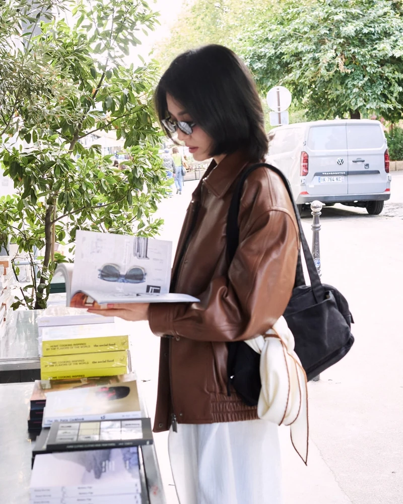 송혜교가 계절마다 쓰는🧡🤍스카프
가을엔 아이보리 로장지, 여름은 그린 반다나🧣에르메스 스카프 2장
가을 그녀는 브라운 램스킨 블루종에 아이보리 스카프를 목에 두 번 감은 룩을 했어요. 에르메스(HERMÈS) 'New Libris 로장지'로, 마름모꼴이라 목에 감으면 뾰족한 두 끝이 앞으로 떨어집니다. 같은 날 서점과 갤러리에선 풀어서 블랙 숄더백 스트랩에 리본처럼 묶었죠.
여름엔 에르메스 다른 스카프를 다르게 썼어요. 7월 크로셰 톱에 데님을 입은 날 그린 '레 토르튀 반다나 55'를 허리춤에 묶었는데, 거북이 무늬가 든 작은 사이즈라 허리나 가방 손잡이에 감는 쪽이 맞아요.
여름 반다나가 장식이었다면 가을 로장지는 기능이 먼저예요. 코트를 꺼내기 전 마지막 한 장으로 아침엔 목에 감고 낮엔 풀어 가방에 묶는 것까지가 송혜교식 간절기 대응이니, 캐시미어 혼방 마름모꼴 스카프 한 장으로 참고하세요.
• 에르메스 New Libris 로장지, 164만 원대
• 에르메스 Les Tortues 반다나 55, 48만 원대 이미지2