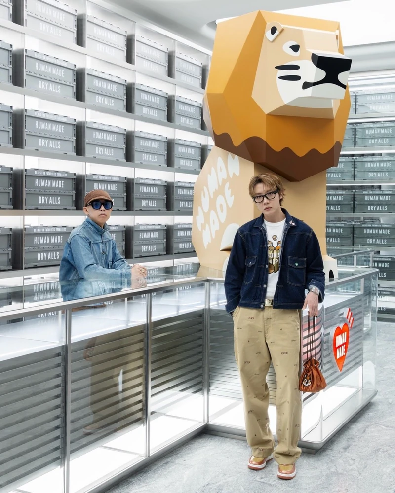 가이드는 니고, 손님은 제이홉🦁
휴먼 호프 시즌 2 발매 직전, 본인이 만든 옷 입고 등장!❤️
휴먼 메이드의 니고가 제이홉을 위한 특별 투어를 직접 이끌었어요. 대형 사자 조형물과 휴먼 메이드 수납 박스가 벽을 가득 채운 매장에서 두 사람이 나란히 섰습니다.
제이홉은 다람쥐 그래픽 티셔츠에 네이비 데님 워크 자켓, 패턴 치노 팬츠를 매치하고 다람쥐 얼굴 파우치를 들었어요. 다람쥐 그래픽은 두 사람이 함께 만든 협업 '휴먼 호프(HUMAN HOPE)'의 상징이죠. 두 번째 시즌은 데님 워크 자켓과 치노 팬츠, 수납 박스까지 16종으로 9월 26일 발매됩니다.
• 휴먼 호프 시즌 2, 9월 26일 발매 이미지1