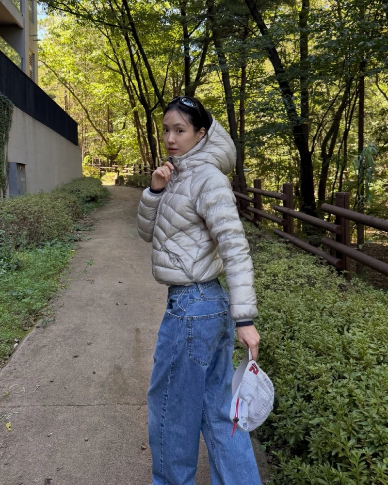 또 나만 없을 수 없지🩶'에어플로우'
손나은이 데님에 메시 캡으로 코디한🌪️💙핏 좋은 경량다운 참고!
최근 손나은이 산책 때 입은건 휠라 에어플로우 후드 경량 다운이에요. 크롭 기장 아래로 리바이스 와이드 데님을 매치하고, 알렉스 조노 메시 캡도 함께 했습니다.
류혜영도 같은 패딩을 다크 브라운 롱 플레어 스커트와 입었었죠. 미니멀한 블랙 플랫에, 지퍼 아래쪽을 열어 그레이 니트를 살짝 드러내 코디했어요.
휠라 에어플로우는 곡선 퀼팅에 비치는 원단을 써 충전재가 은은하게 보입니다. 특히 밑단 스트링과 투웨이 지퍼로 핏이 조절되는게 핵심이에요.
• 휠라 에어플로우 후드 경량 다운, 21만 원대 이미지1