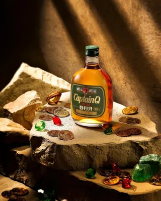 추억의 양주, 캪틴큐가 돌아왔다🥃
2015년 단종됐던 ‘캪틴큐’가 11년 만에 부활합니다. 1980~90년대 양주의 대중화를 이끌었던 제품인데요. 새 캪틴큐는 캐리비안 럼 원액을 버번 캐스크와 PX 셰리 캐스크에서 숙성해 달콤하고 부드러운 풍미를 강조했습니다. 360mL, 알코올 도수는 35%.
과거의 짙은 녹색 병 디자인도 그대로 살렸으며, 제품 2병과 전용 잔, 기념주화가 담긴 ‘캪틴큐 보물상자’ 1만2천 세트도 한정 출시됩니다. 이 가운데 1980세트에는 순은 기념주화가 랜덤으로 들어간다고 합니다. 10월 14일부터 편의점 CU에서 판매 예정입니다. 이미지