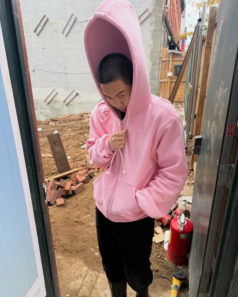 후드가 한 뼘 더 솟았다🩷☝️
특별한 인싸템🐘듀벳 핑크 엘리펀트 후디, 머리 위로 길쭉!
뉴욕 거리에서 후드가 머리 위로 길쭉하게 솟은 핑크 후디가 포착됐어요. 크리에이터 제이스(@jacelnn)가 입은 뉴욕 브랜드 듀벳(DUVETT)(@__duvett__)의 '핑크 엘리펀트 후디'죠.
오버사이즈 후디를 깊게 눌러쓰던 저스틴 비버 무드에서 후드 높이만 과장한 셈입니다. 소매와 몸판 곳곳은 찢어진 디스트레스드 디테일로 마무리했어요.
듀벳은 코끼리 로고를 쓰는 뉴욕 브랜드로, 이 후디를 225달러에 한정 수량으로 냈습니다. 이름부터 '익스트라 롱'인 캡도 같이 팔고 있죠.
• 듀벳 핑크 엘리펀트 후디, 225달러 이미지2