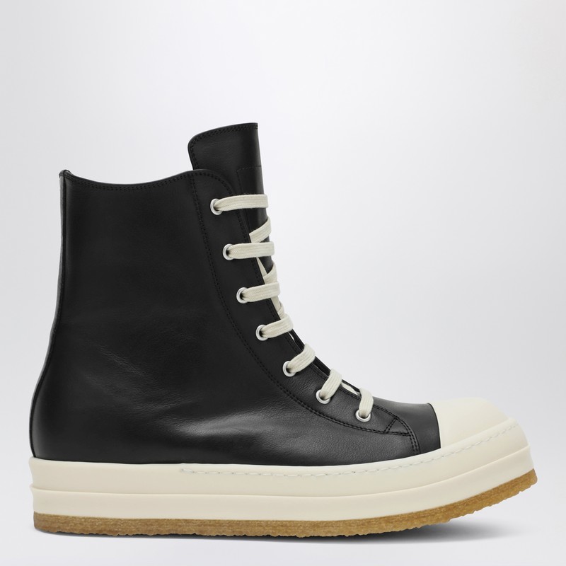 검은색 가죽 소재의 릭 오웬스 스니커즈. 우유빛 흰색 고무로 된 둥근 앞부분, 끈으로 묶는 잠금장치, 긴 혀, 안쪽 지퍼, 고무 밑창이 특징입니다. 이미지