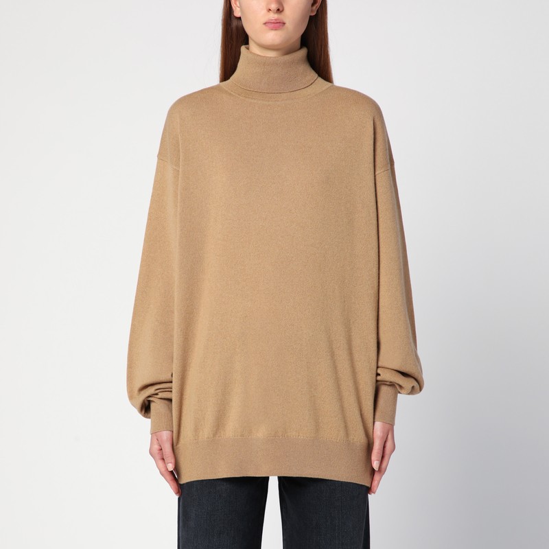 드리스 반 노튼의 베이지색 캐시미어 점퍼는 높은 칼라, 긴 소매, 옆 슬릿, 리브 가장자리와 느슨한 핏이 특징입니다. 이미지