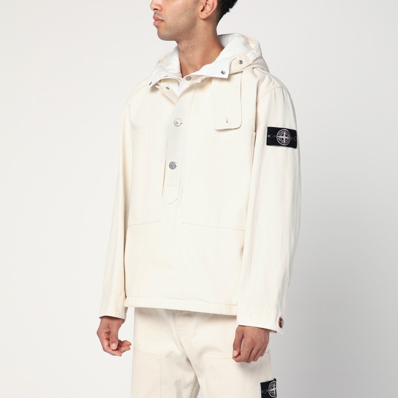 아이보리 코튼 소재의 Stone Island 아노락은 끈이 달린 후드, 턱끈, 3개 단추 잠금 장치, 큰 가슴 주머니, 긴 소매(하나는 Compass 로고 라벨이 있음), 조절 가능한 커프스가 특징입니다. 이미지