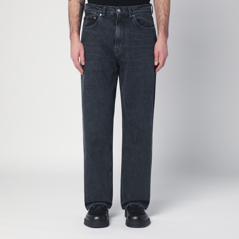 짙은 회색 코튼 데님 소재의 레거시 청바지는 클래식 포켓 5개, 앞면 지퍼와 단추 잠금 장치, 벨트 고리, 뒷면 로고 패치가 특징입니다. 이미지