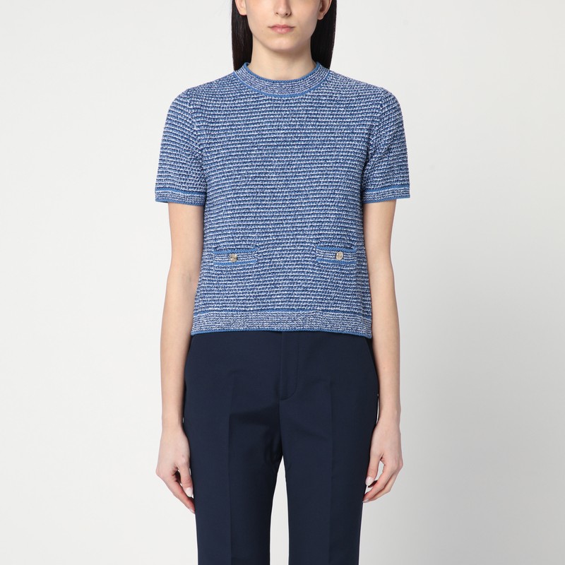 밝은 파란색 코튼 니트 소재의 구찌 크루넥 스웨터는 짧은 소매, GG 로고가 있는 황금색 단추가 달린 앞면 웰트 포켓 2개, 리브 가장자리가 특징입니다. 이미지