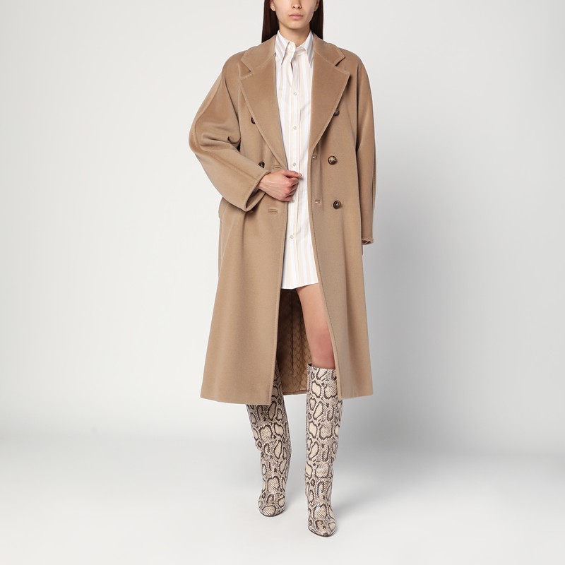 Max Mara의 캐멀 컬러 울과 캐시미어 소재의 더블 브레스트 코트는 오버사이즈 핏, 클래식한 와이드 라펠, 긴 컨버터블 기모노 슬리브, 두 개의 사이드 웰트 포켓, 버튼 잠금 장치가 특징입니다. 이미지