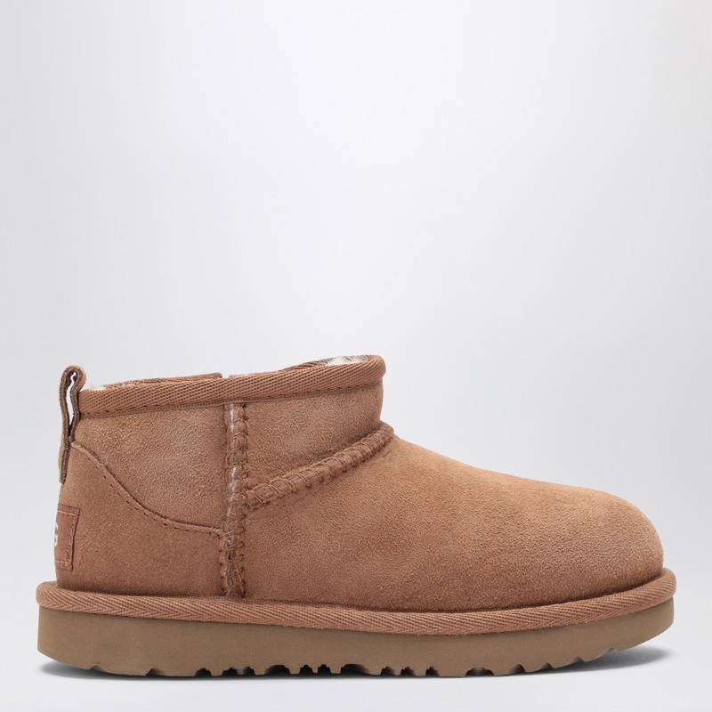 UGG의 밤색 스웨이드 양가죽 로우 부츠는 양가죽 안감, 둥근 앞부분, 뒷면 로고 패치, 풀러, 옆면 지퍼 및 EVA 사탕수수 밑창이 특징입니다. 이미지
