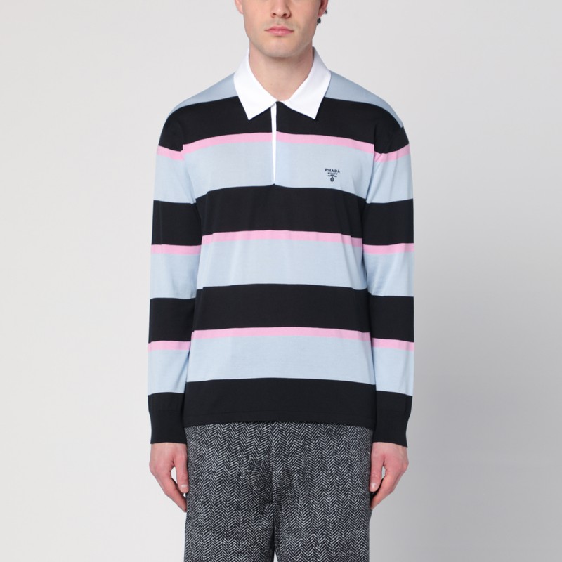 앞면에 숨겨진 단추, 대조적인 흰색 칼라, 리브 커프스가 있는 긴 소매, 가슴에 자수 로고가 있는 검정색, 파란색, 분홍색 줄무늬 실크와 코튼 소재의 프라다 폴로. 이미지