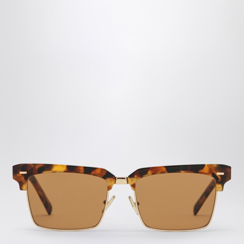 Miu Miu의 밝은 하바나 색상의 아세테이트와 메탈 선글라스. 사각형 디자인, 안경다리에 레터링 로고, 갈색 렌즈가 특징입니다. 이미지