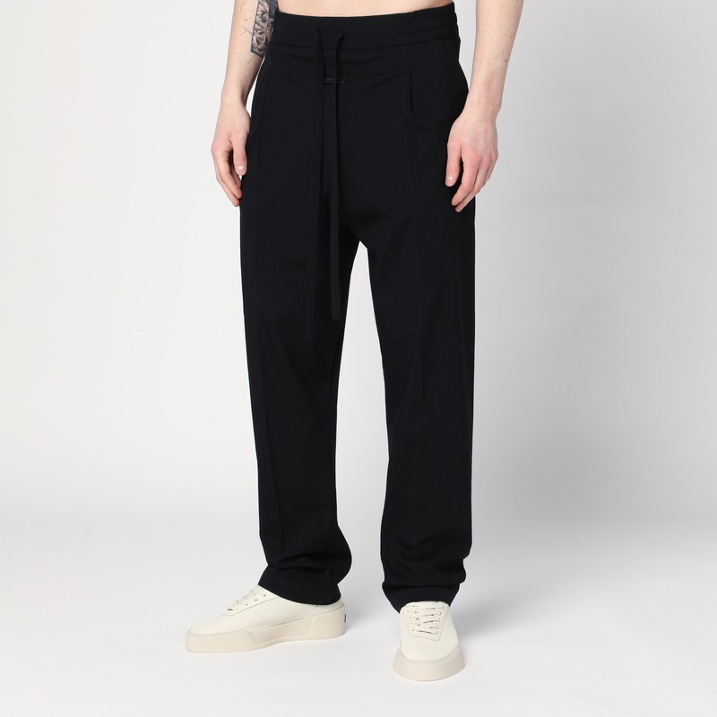 검정색 코튼과 버진 울 블렌드로 만든 Fear of God 팬츠는 끈이 달린 신축성 허리띠, 양쪽 웰트 포켓 2개, 앞면에 고무 로고 패치, 앞면에 주름이 특징입니다. 이미지