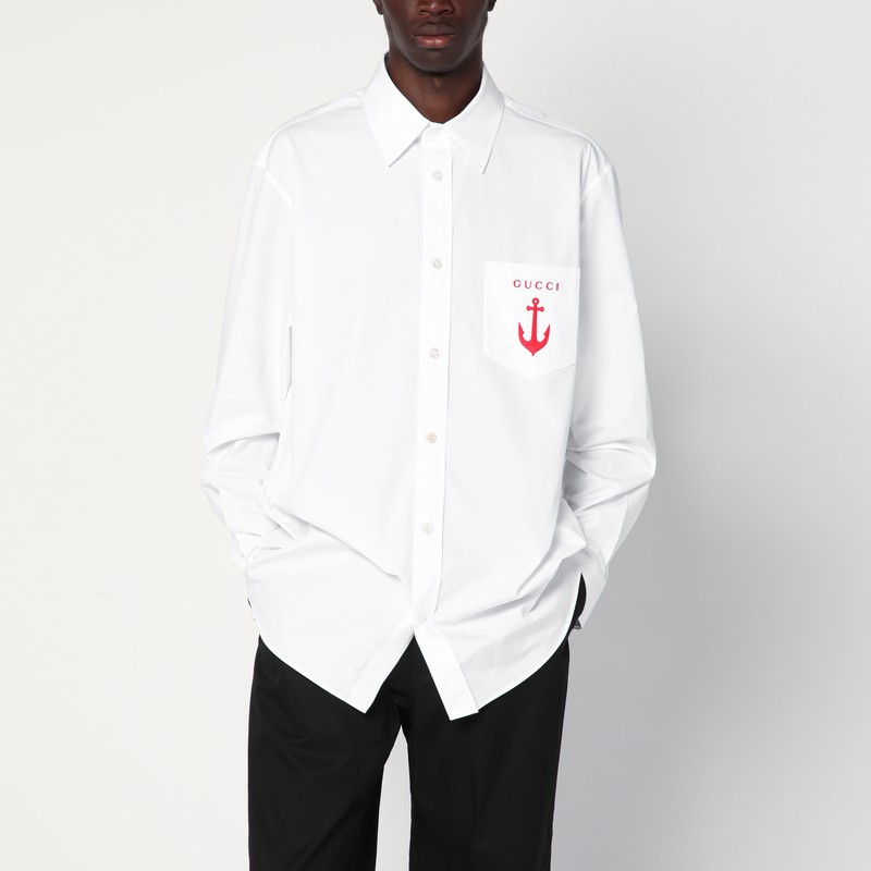 흰색 코튼 팝린 소재의 구찌 셔츠는 뾰족한 칼라, 대조적인 로고 레터링 자수가 있는 가슴 패치 포켓, 단추로 고정되는 커프스가 있는 긴 소매, 앞면 단추 잠금 장치 및 c가 특징입니다. 이미지