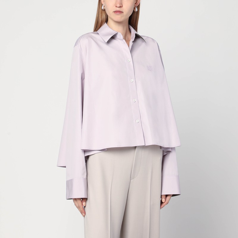 라일락 코튼 팝린 소재의 로에베 셔츠는 짧은 트라페즈 실루엣, 편안한 핏, 클래식 칼라, 앞면 버튼 잠금, 버튼 커프스가 있는 긴 소매, 톤온톤 아나그램 로고가 특징입니다. 이미지
