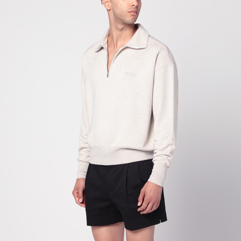 자연스러운 색상의 코튼 소재로 만든 프라다 폴로 셔츠는 긴 소매, 지퍼 칼라, 박스형 핏, 가슴 부분에 빈티지 효과의 로고 레터링, 리브 트림이 특징입니다. 이미지