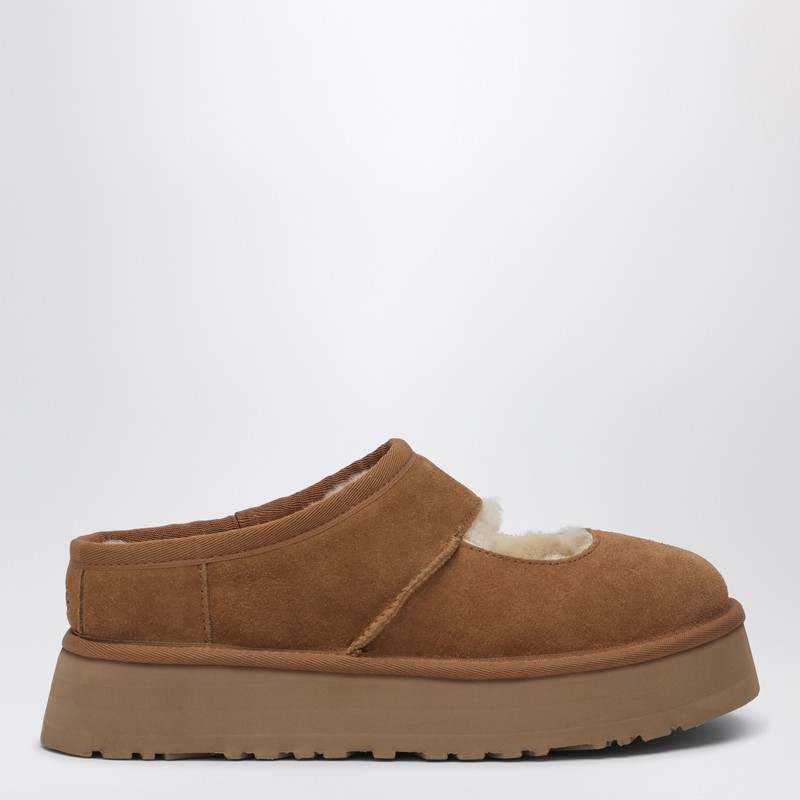 밤색 스웨이드 소재의 플래토 Ugg 메리 제인. 털 안감, UGG 플러시 깔창, 패딩 칼라, 폼 안창, EVA 미드솔과 아웃솔, 뒷면에 새겨진 로고가 특징입니다. 이미지