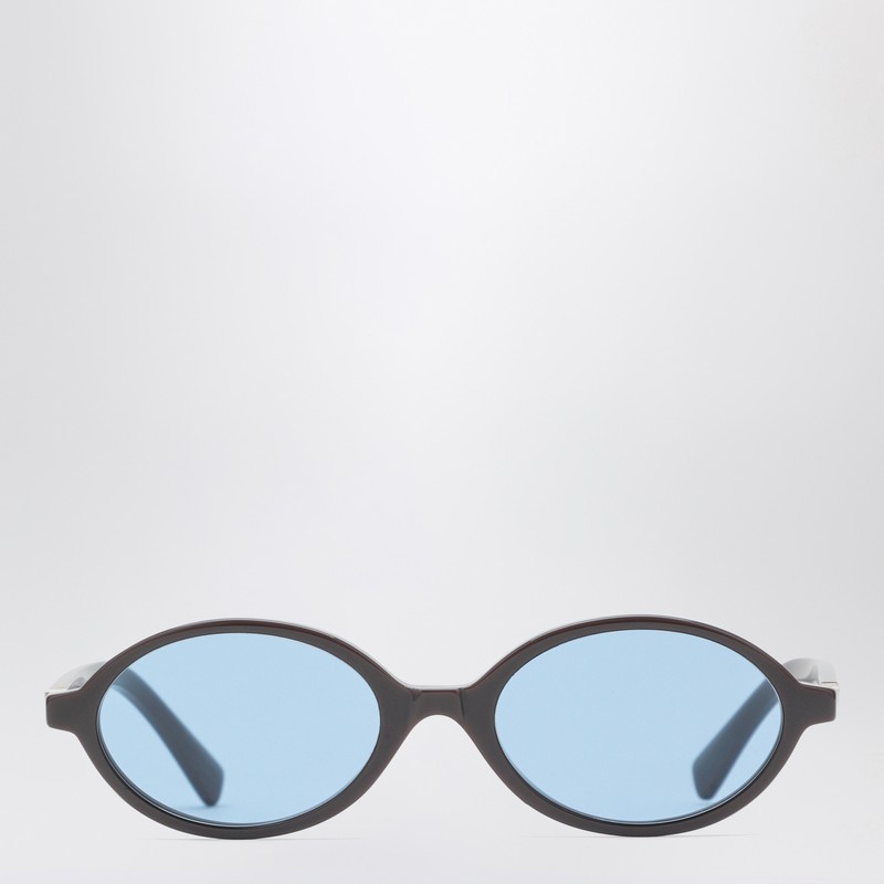 모카색 아세테이트 소재의 Miu Miu 선글라스는 타원형 프레임, 100% UVA/UVB 보호 기능이 있는 파란색 렌즈, 로고가 새겨진 템플이 특징입니다. 이 프레임은 처방 안경과 호환되지 않습니다. 이미지