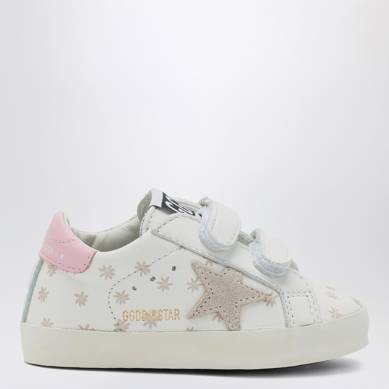 골든구스 디럭스 브랜드의 흰색 가죽 스니커즈로, 전면에 핑크색 꽃 장식, 로고가 새겨진 벨크로 잠금 장치, 둥근 앞부분, 옆면에 스웨이드 별 모양 장식, 고무 밑창이 특징입니다. 이미지