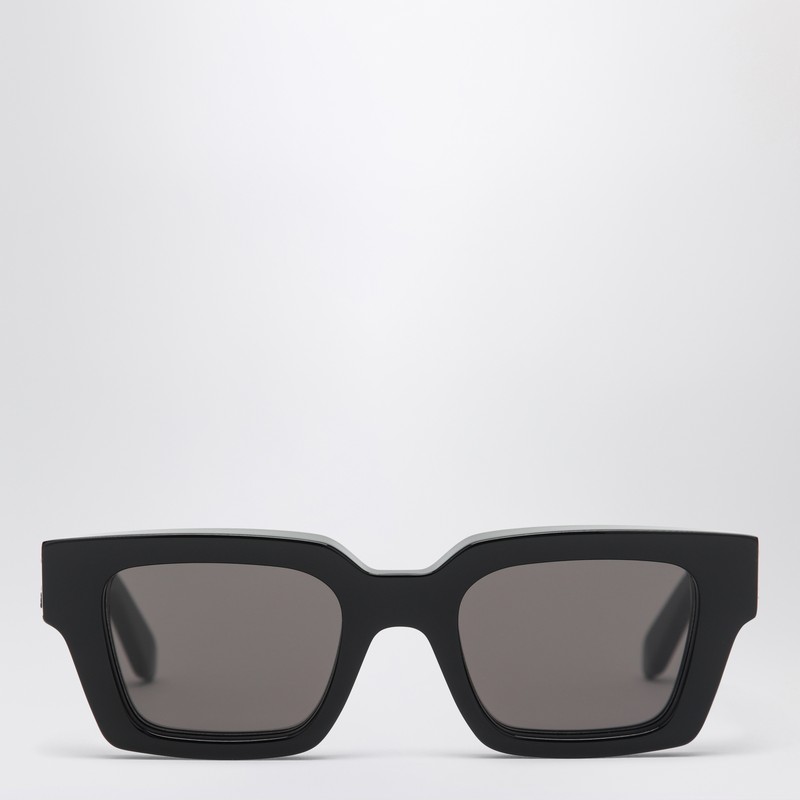 Off-White의 짙은 회색 렌즈가 달린 검은색 아세테이트 선글라스. 직사각형 프레임과 관자놀이 부분에 화살표 패턴 로고가 특징입니다. 이미지