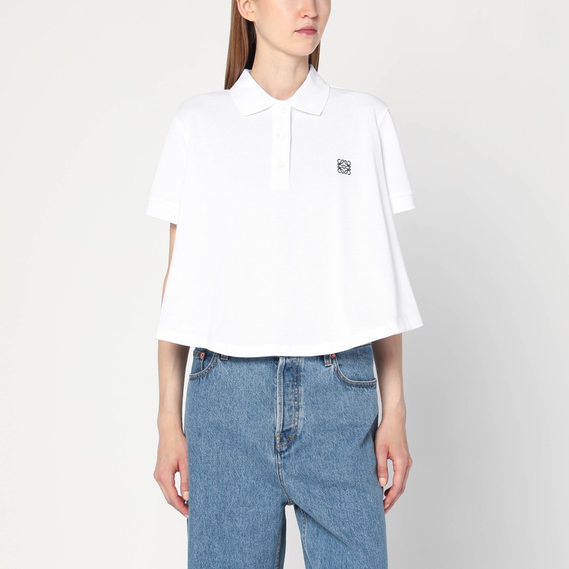 흰색 코튼 피케 소재의 로에베 폴로 셔츠는 짧은 소매, 앞면의 단추, 트라페즈 실루엣, 편안한 핏, 짧은 길이, 가슴 부분에 대조적인 아나그램 로고 자수가 특징입니다. 이미지