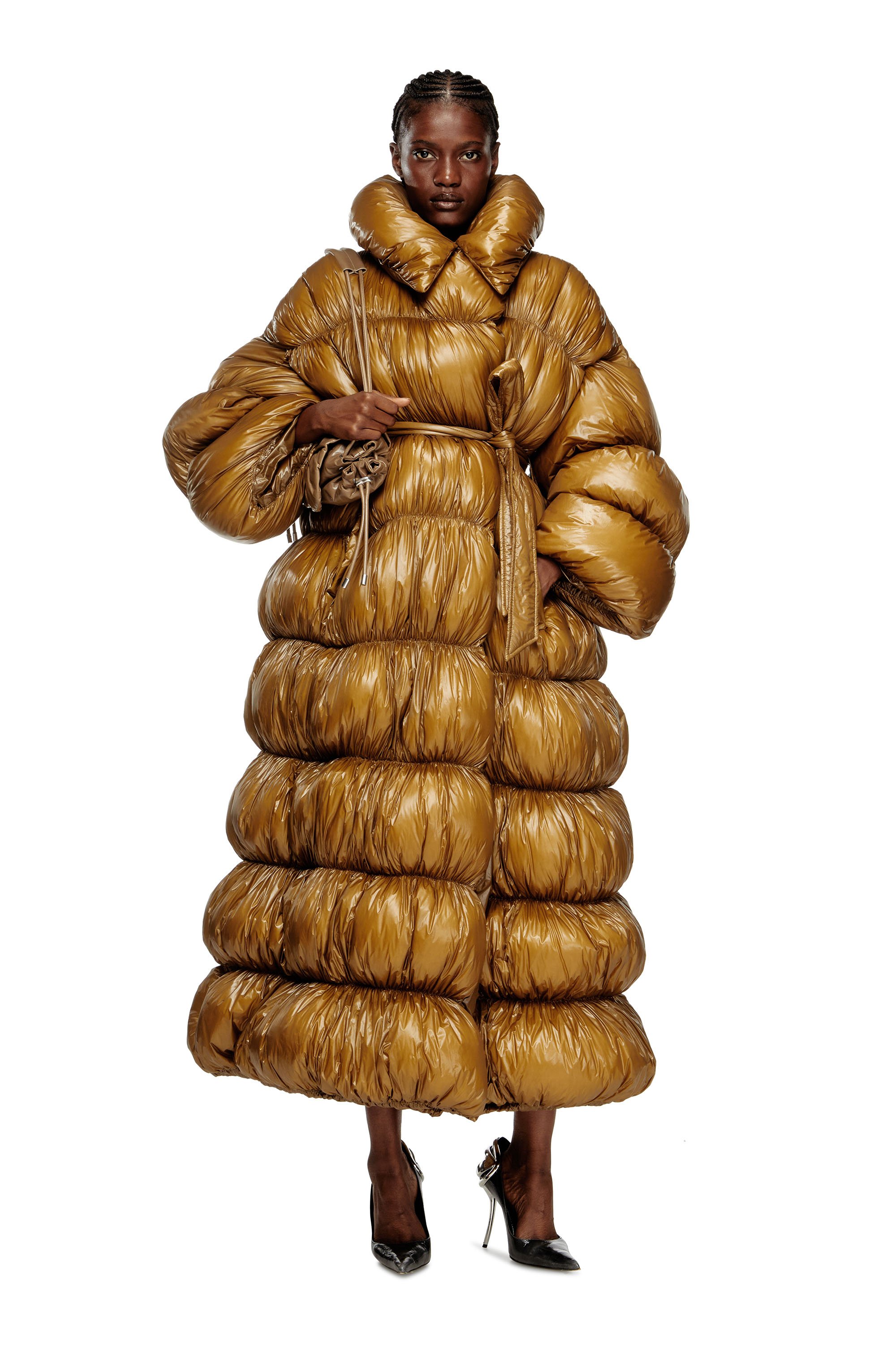 높고 낮은 미학의 충돌인 이 여성용 롱 코트는 부풀어 오른 거품과 같은 비율과 더블 브레스트 앞면과 같은 보다 공식적인 요소를 갖춘 고전적인 퍼퍼 실루엣을 재구성합니다. 이미지