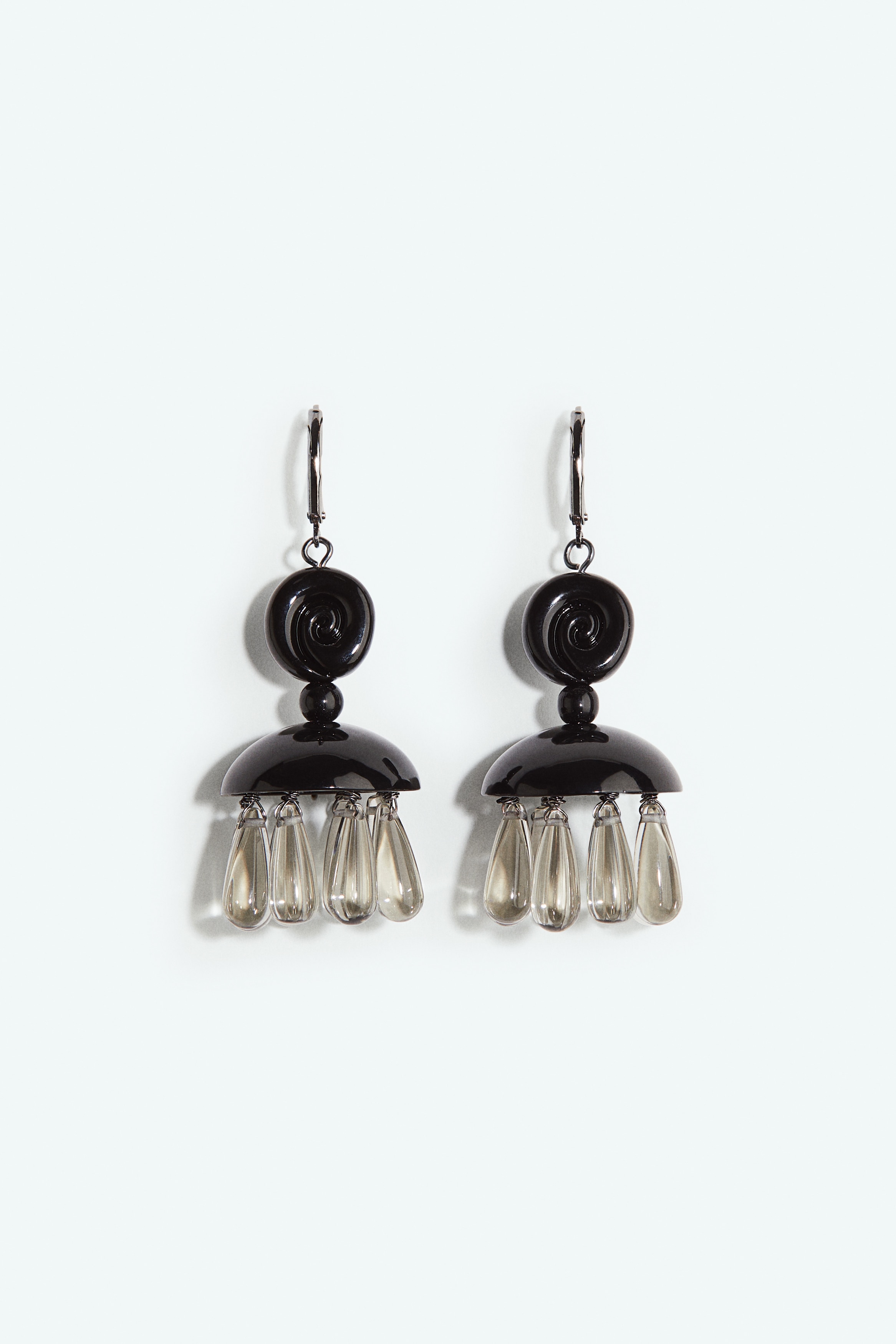 Dangle earrings featuring a swirl-patterned disc and a dome-shaped detail adorned with drop-shaped beads hanging below. The earrings are secured with a leverback clasp. 이미지
