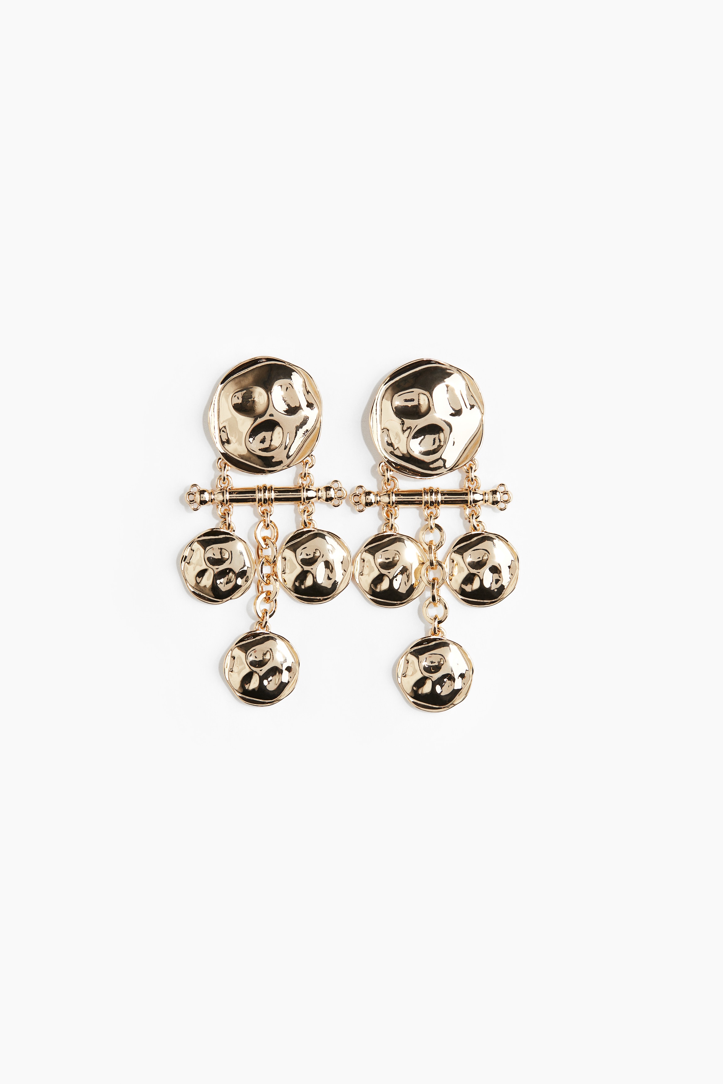 상단의 납작한 원형 피스에 텍스처가 있는 금속 귀걸이. 가로 방향의 막대 하단에 달린 작고 납작한 원형 펜던트 장식이 움직임에 따라 부드럽게 흔들리는 디자인. 이미지