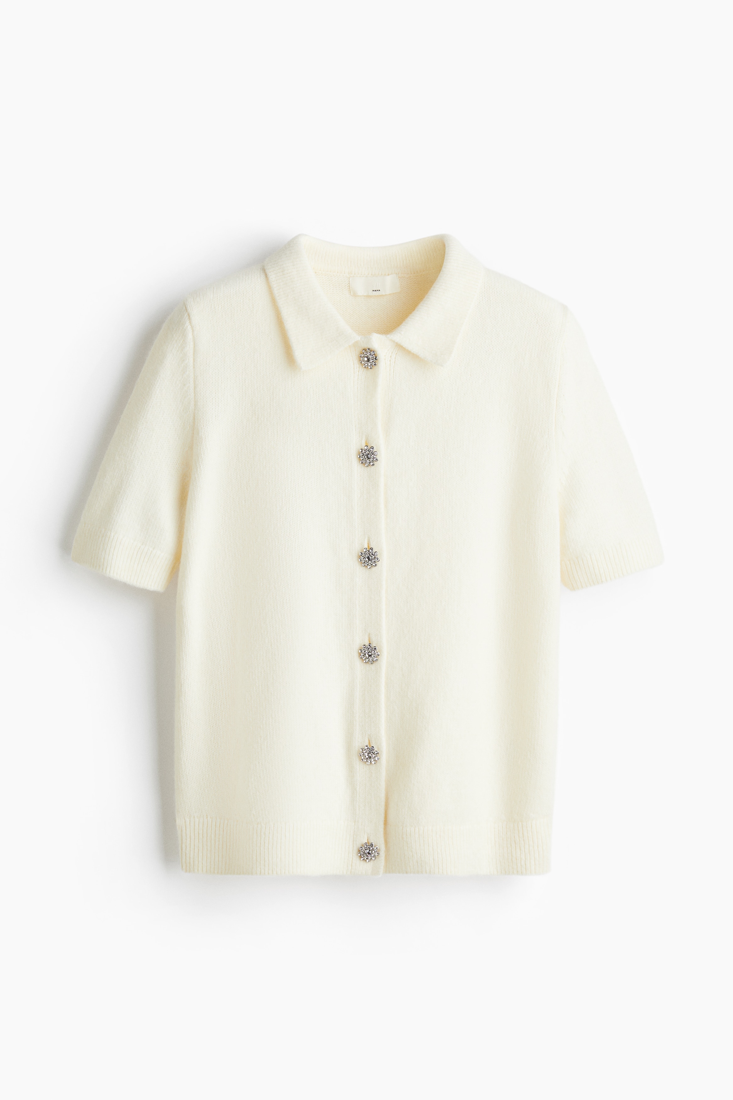 칼라가 있는 부드러운 니트 소재의 반소매 가디건. 라인스톤으로 장식된 앞면 버튼. 리브드 소맷단과 아랫단. 이미지