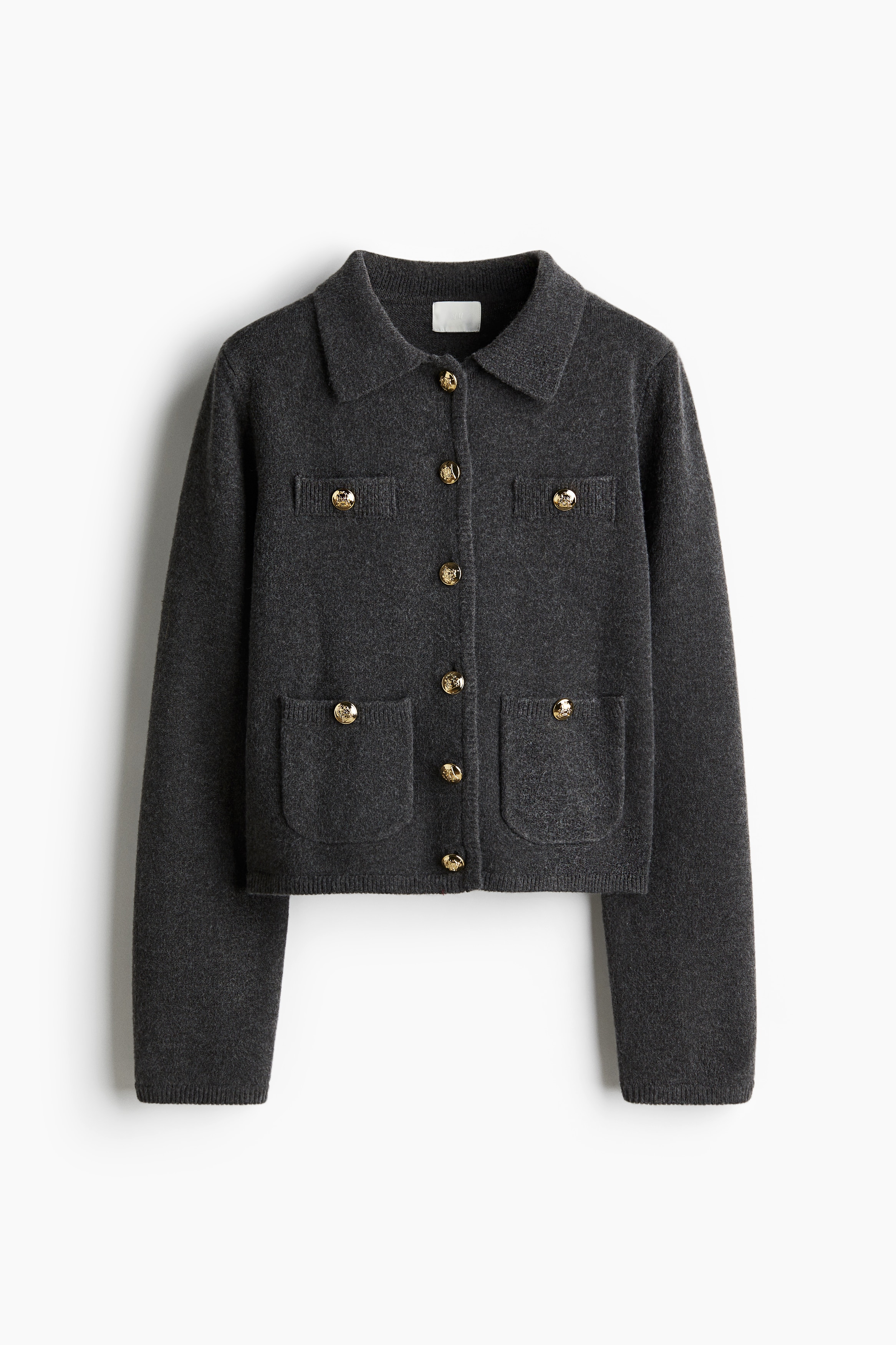 부드러운 파인니트 소재의 가디건. 칼라와 앞면 금속 버튼이 있음. 버튼 장식이 있는 앞면 패치포켓과 가슴 페이크 포켓. 이미지