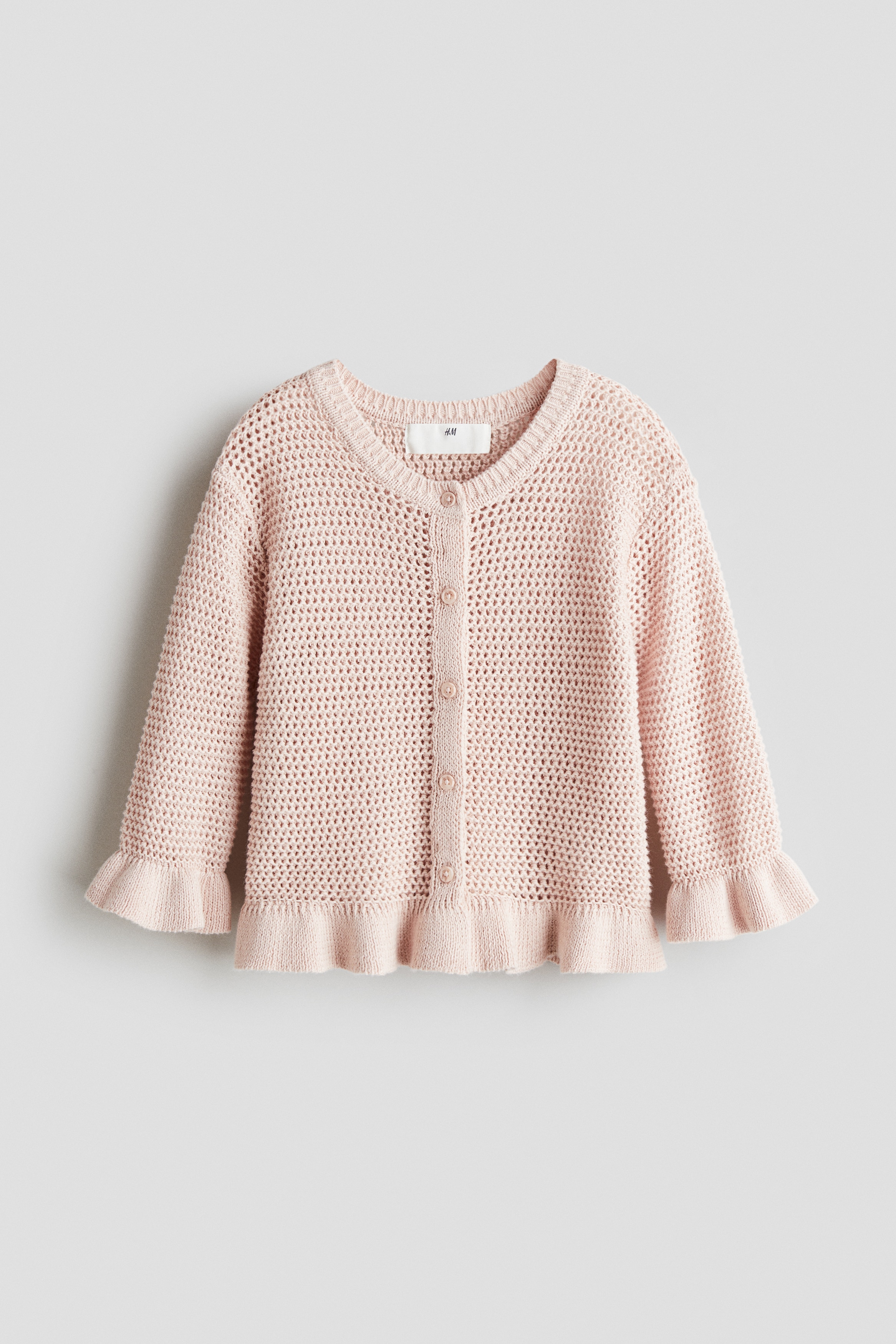 크로셰 느낌을 준 부드러운 니트 소재의 버튼업 스타일 가디건. 리브드 마감된 네크라인. 7부 소매. 프릴 소맷단과 아랫단. 이미지