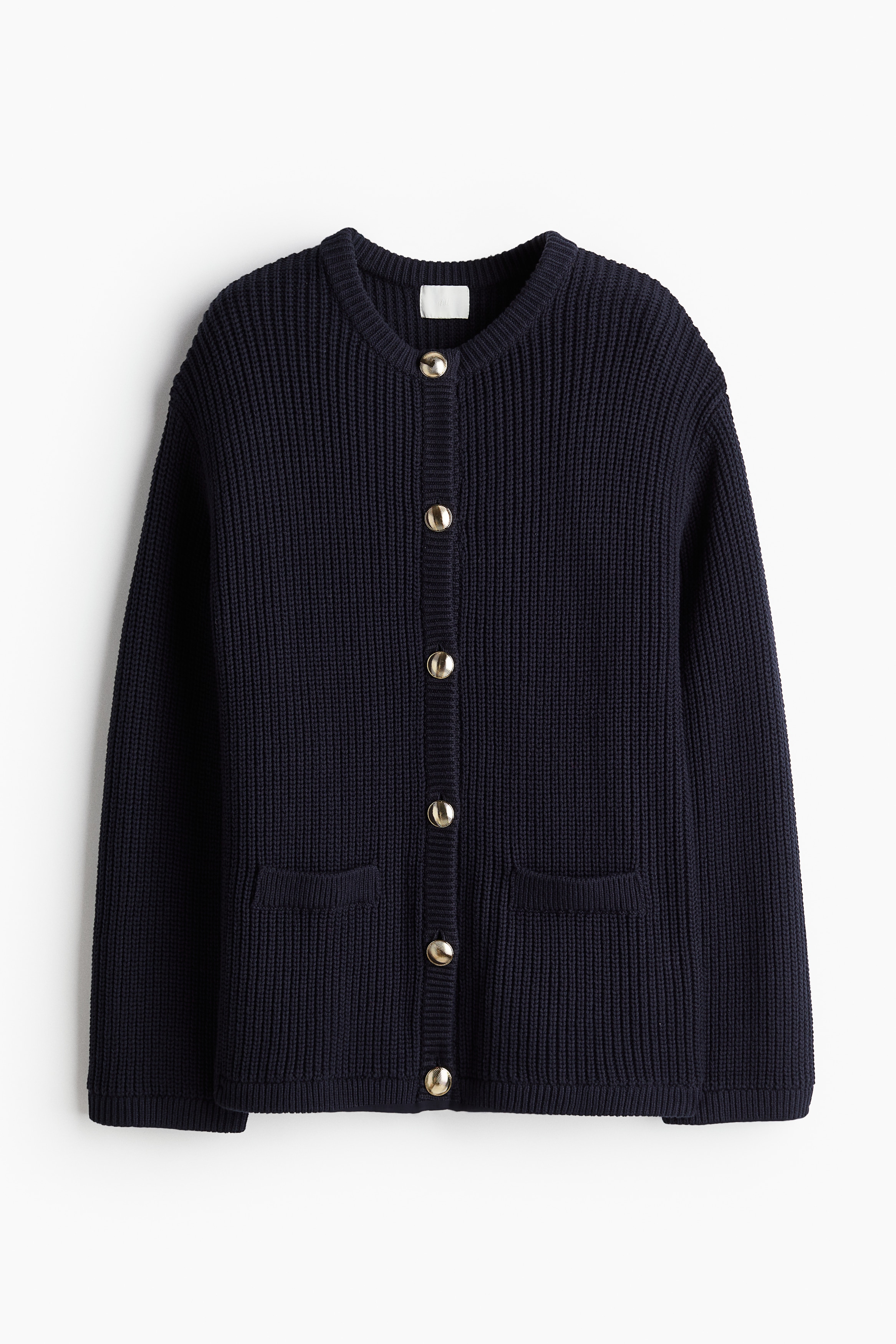 코튼이 혼방된 리브니트 소재의 세미 롱 가디건. 루즈핏. 라운드넥. 골드 컬러의 앞면 금속 버튼. 앞면 페이크 포켓. 드롭 숄더. 긴소매. 이미지