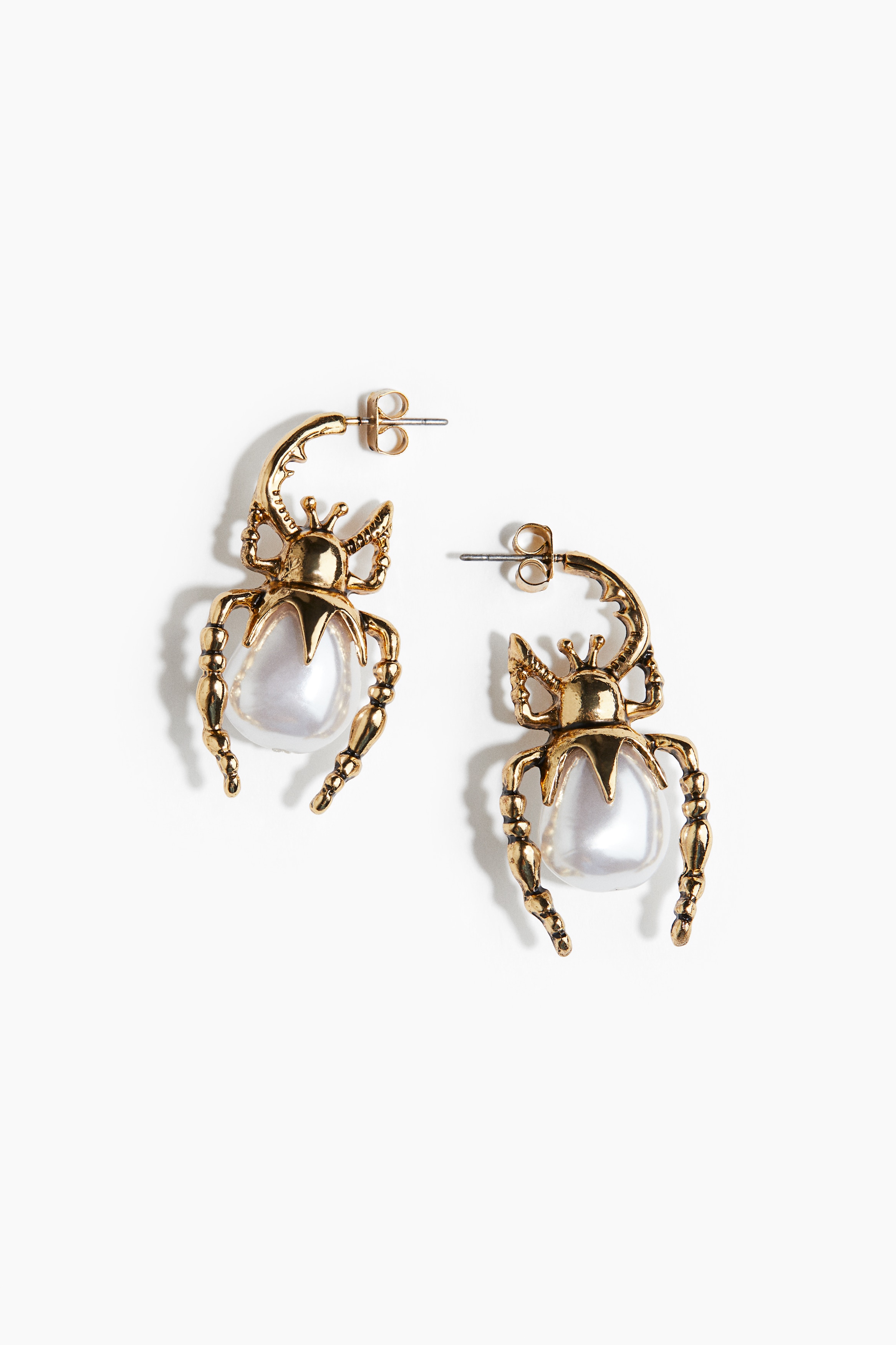 플라스틱 펄 비즈로 장식된 거미 모양의 금속 귀걸이. 이미지