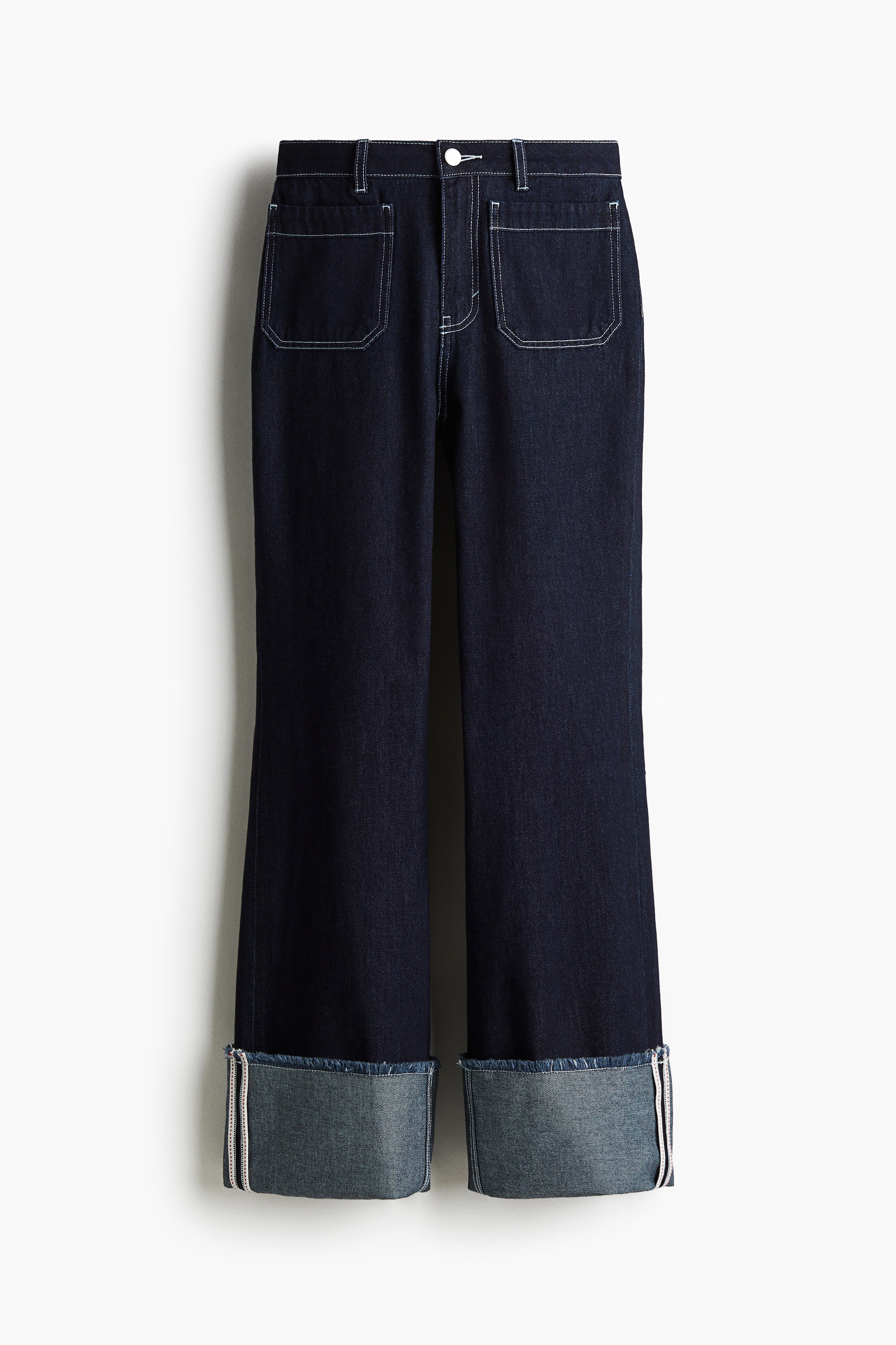 데님 소재의 레귤러 웨이스트 팬츠. 지퍼와 버튼 클로징. 앞뒷면 포켓. 매우 긴 세미 플레어 레그. 단처리를 생략한 아랫단을 접어 다양하게 연출할 수 있음. 이미지