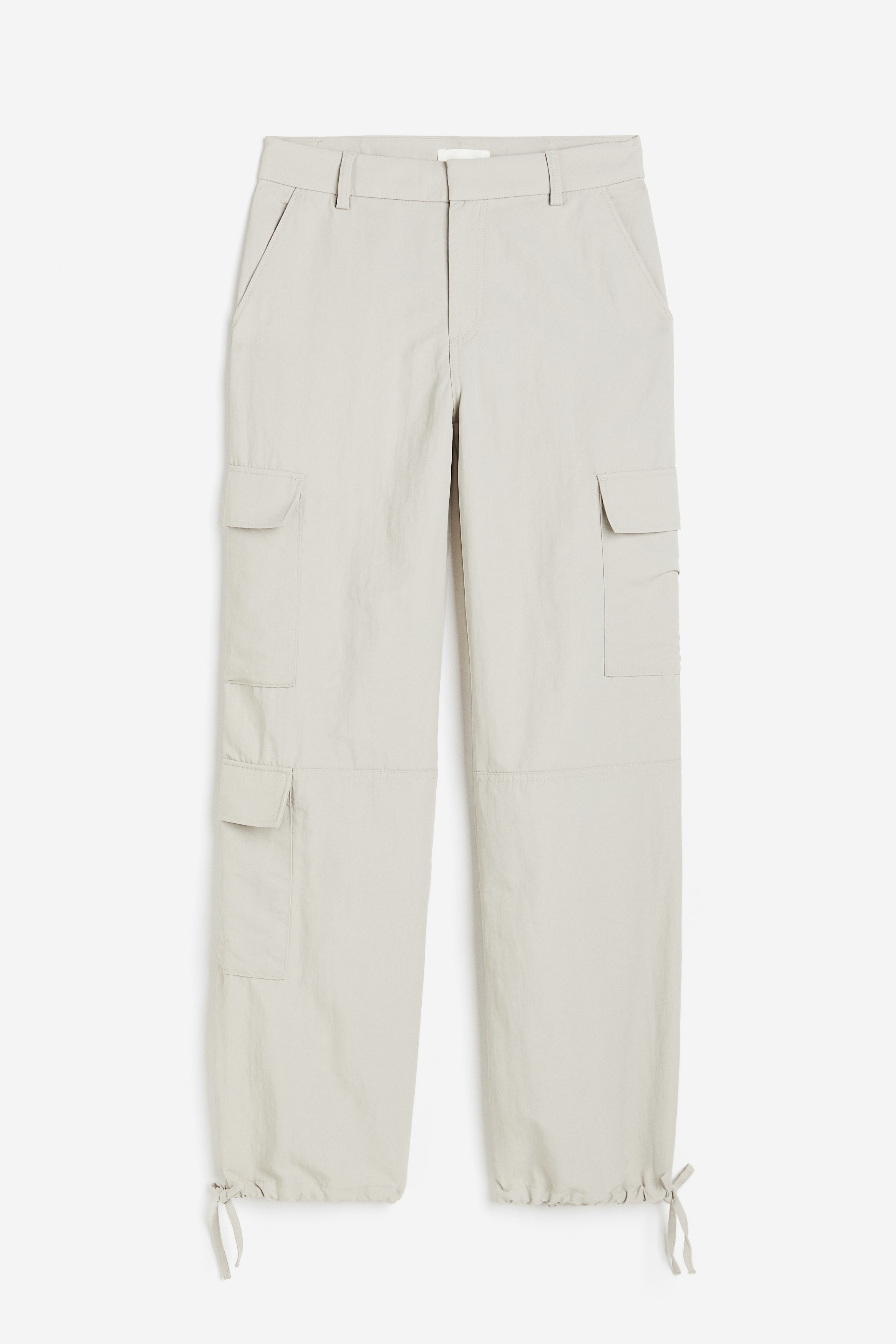 하이웨이스트 스타일의 트윌 팬츠. 지퍼와 후크 클로징. 사선 방향의 앞면 포켓. 뒷면 포켓. 플랩포켓이 있는 스트레이트 레그. 눈에 띄는 무릎 아래 솔기. 아랫단에 드로스트링이 있음. 이미지