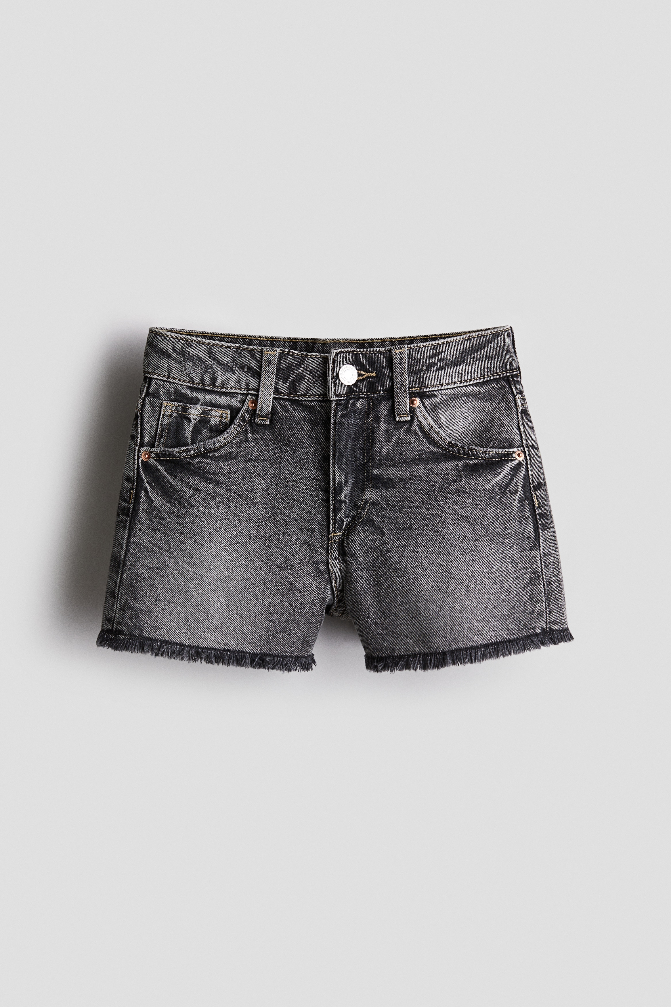 워싱처리된 코튼 데님 소재의 5포켓 반바지. 릴랙스핏. 하이웨이스트. 밴딩으로 허리 사이즈 조절. 지퍼와 버튼 클로저. 단처리를 생략한 아랫단. 이미지