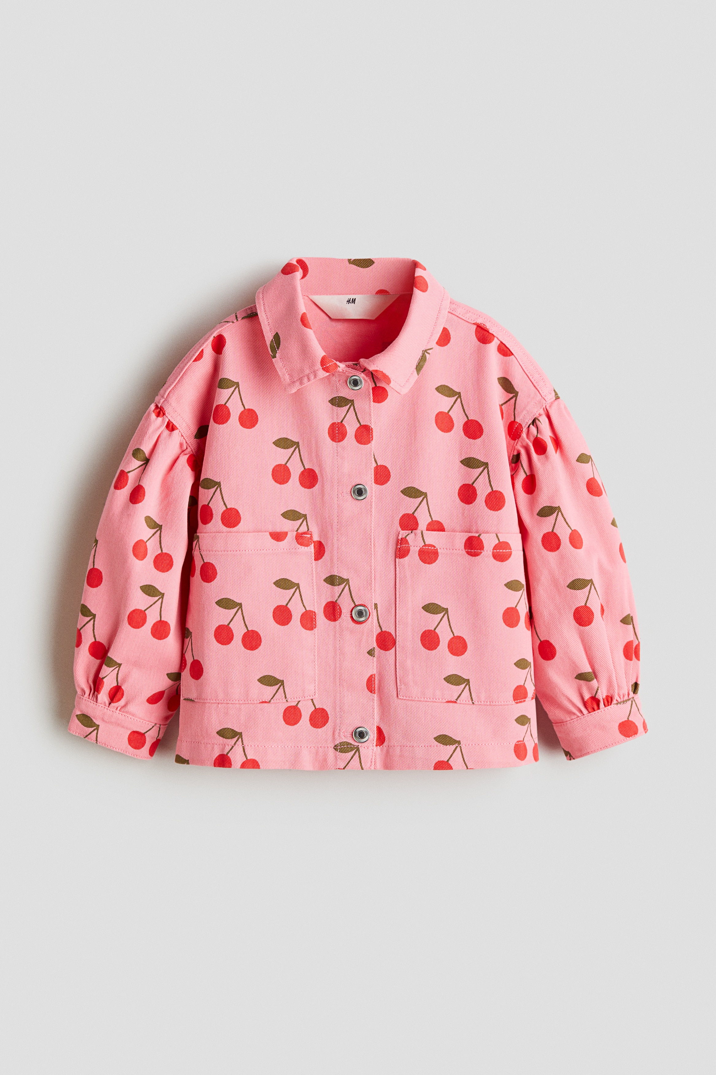 프린트 패턴이 있는 부드러운 코튼 트윌 소재의 루즈핏 재킷. 칼라와 앞면 스냅버튼이 있음. 앞면 패치포켓. 드롭 숄더. 퍼프 스타일의 긴소매. 소맷단 스냅버튼. 안감 생략. 이미지