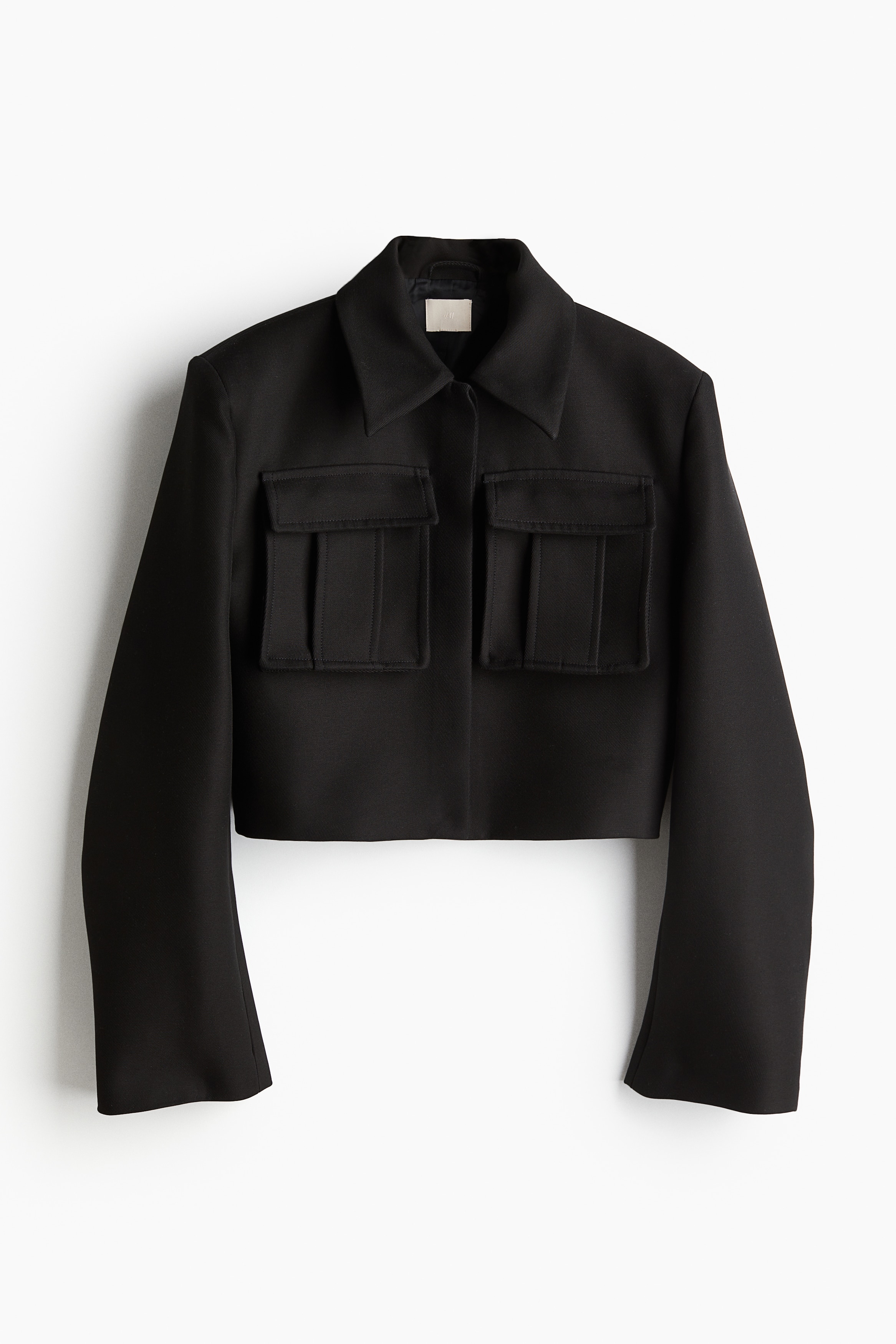 광택감 있는 코튼 혼방 트윌 소재의 짧은 루즈핏 재킷. 포인티드 칼라. 앞면 히든 버튼단. 플랩과 박스 플리츠가 잡힌 가슴 포켓. 숄더 패드 내장. 긴소매. 소맷단 버튼. 비스코스 안감 부착. 이미지